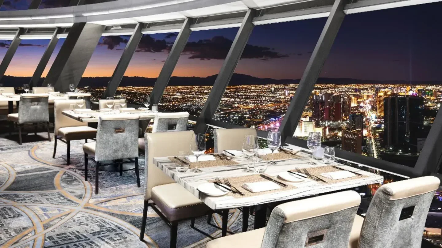 Dining experience at 108 Drinks in Las Vegas with stunning city skyline views at night.