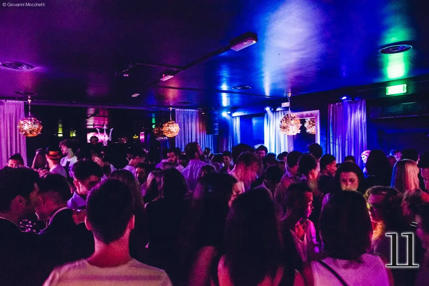 Crowded dance floor at 11Clubroom in Milan, with vibrant club lighting and stylish ambiance.