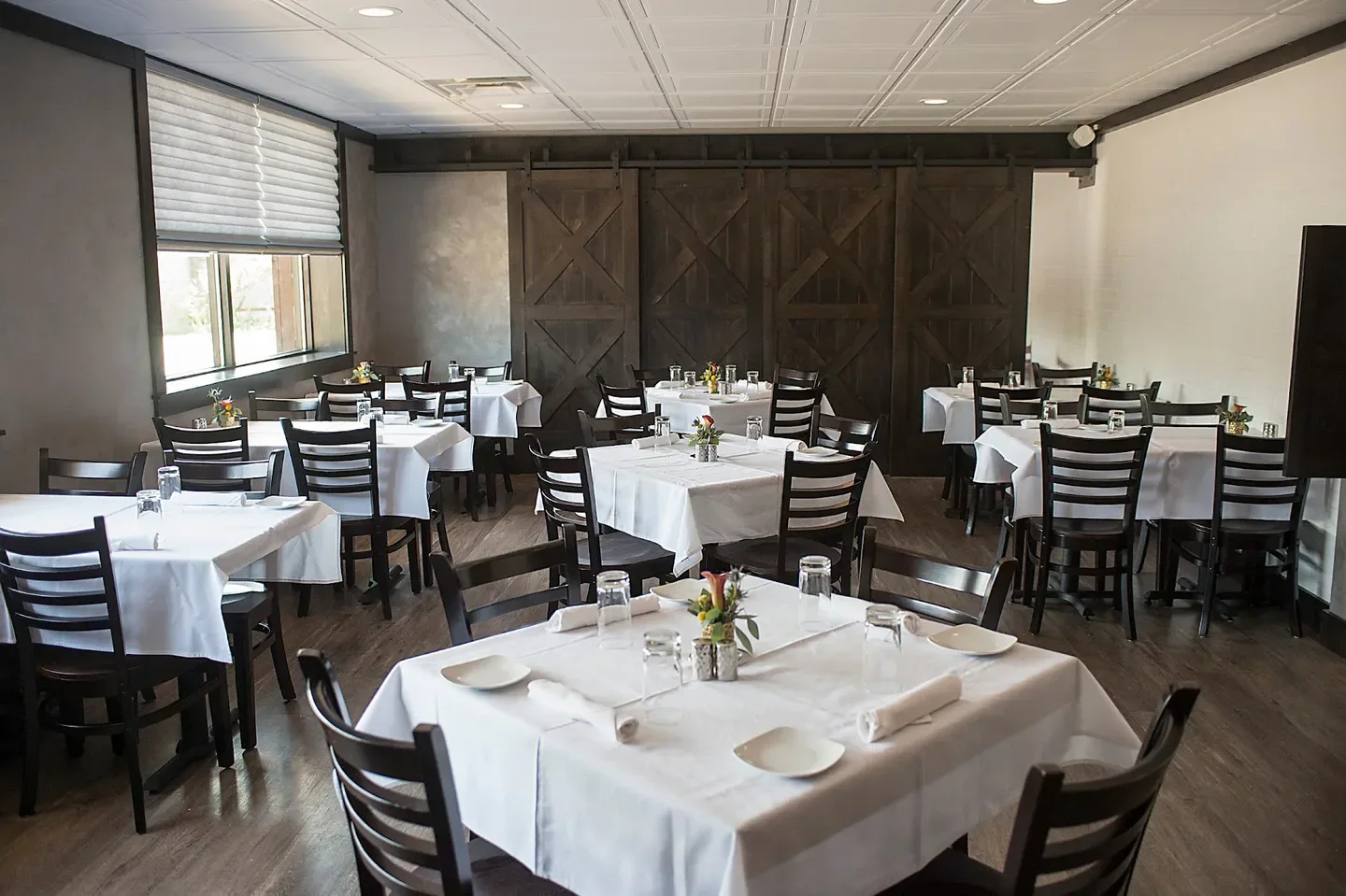 Interior dining room at 1776 Restaurant in Chicago, set tables with white linens.