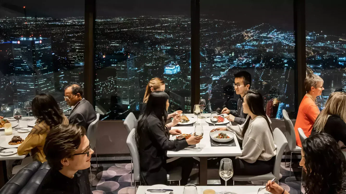 Dining at 360 The Restaurant at the CN Tower in Toronto with city skyline views at night.