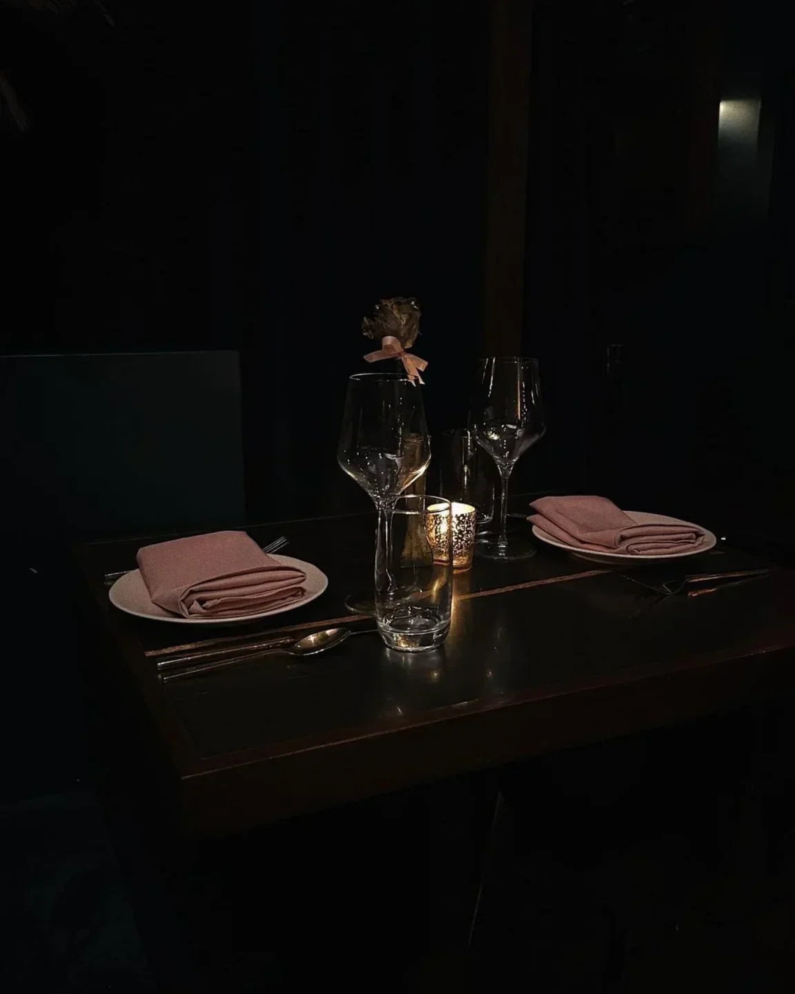 Romantic table setting at 9 Jones in New York City with candlelight and wine glasses.