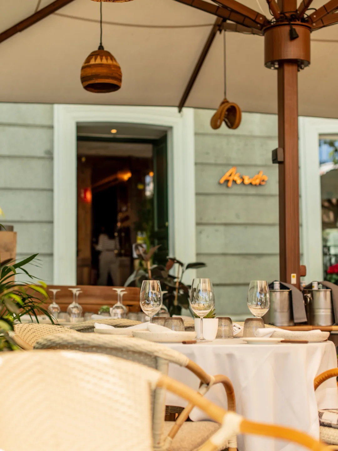 Aarde restaurant interior with elegant table setting and outdoor umbrellas in the city