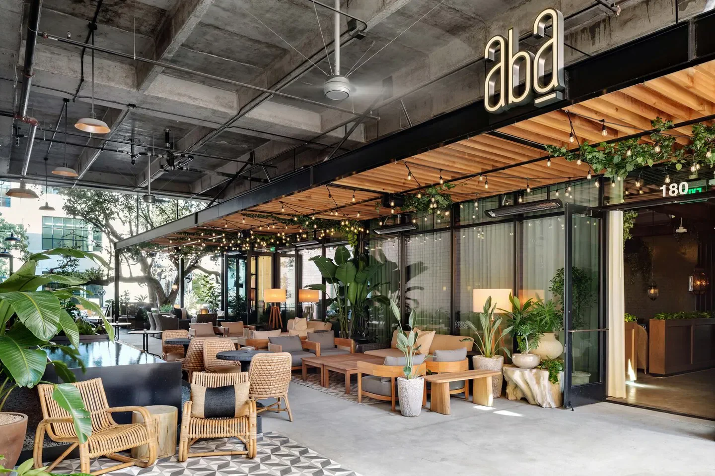 Outdoor seating at Aba - Austin restaurant in Austin with stylish decor and lush greenery.