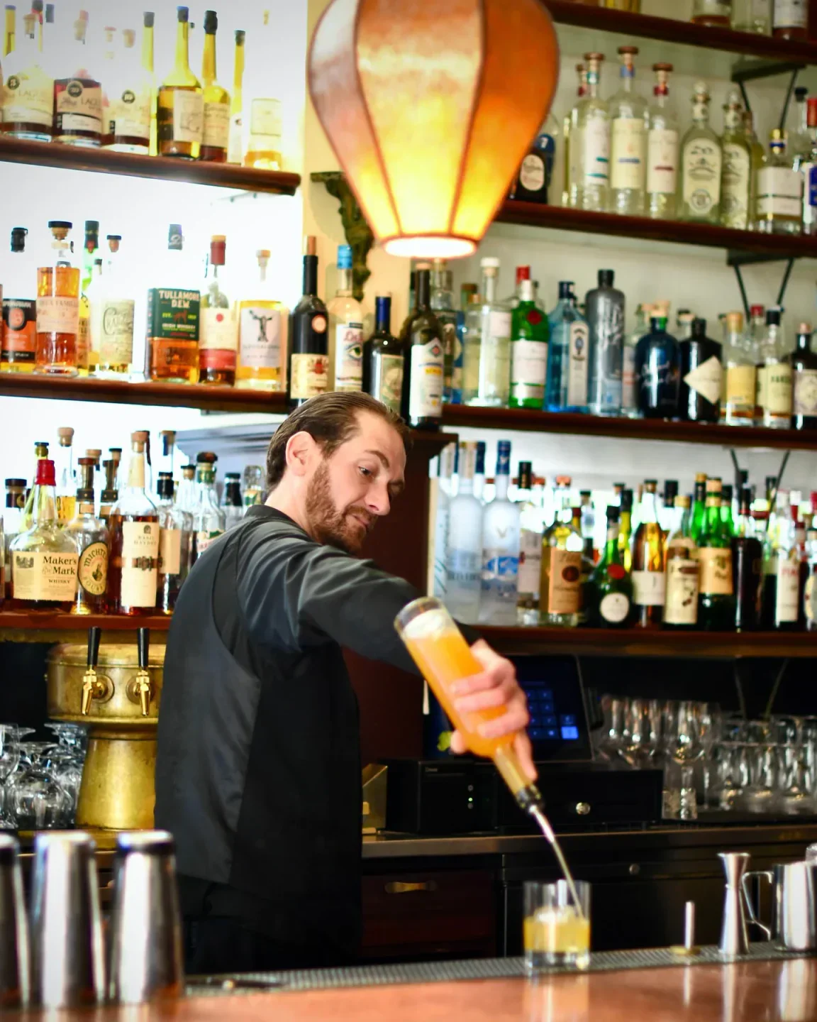Bartender pouring a drink at Absinthe Brasserie & Bar in San Francisco.