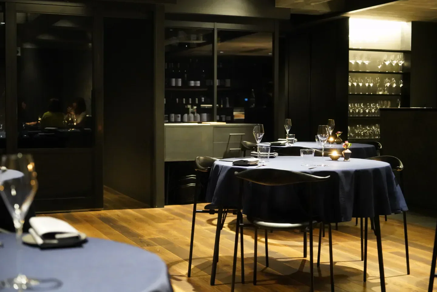 Elegant dining room interior at Abysse restaurant in Tokyo, featuring round tables