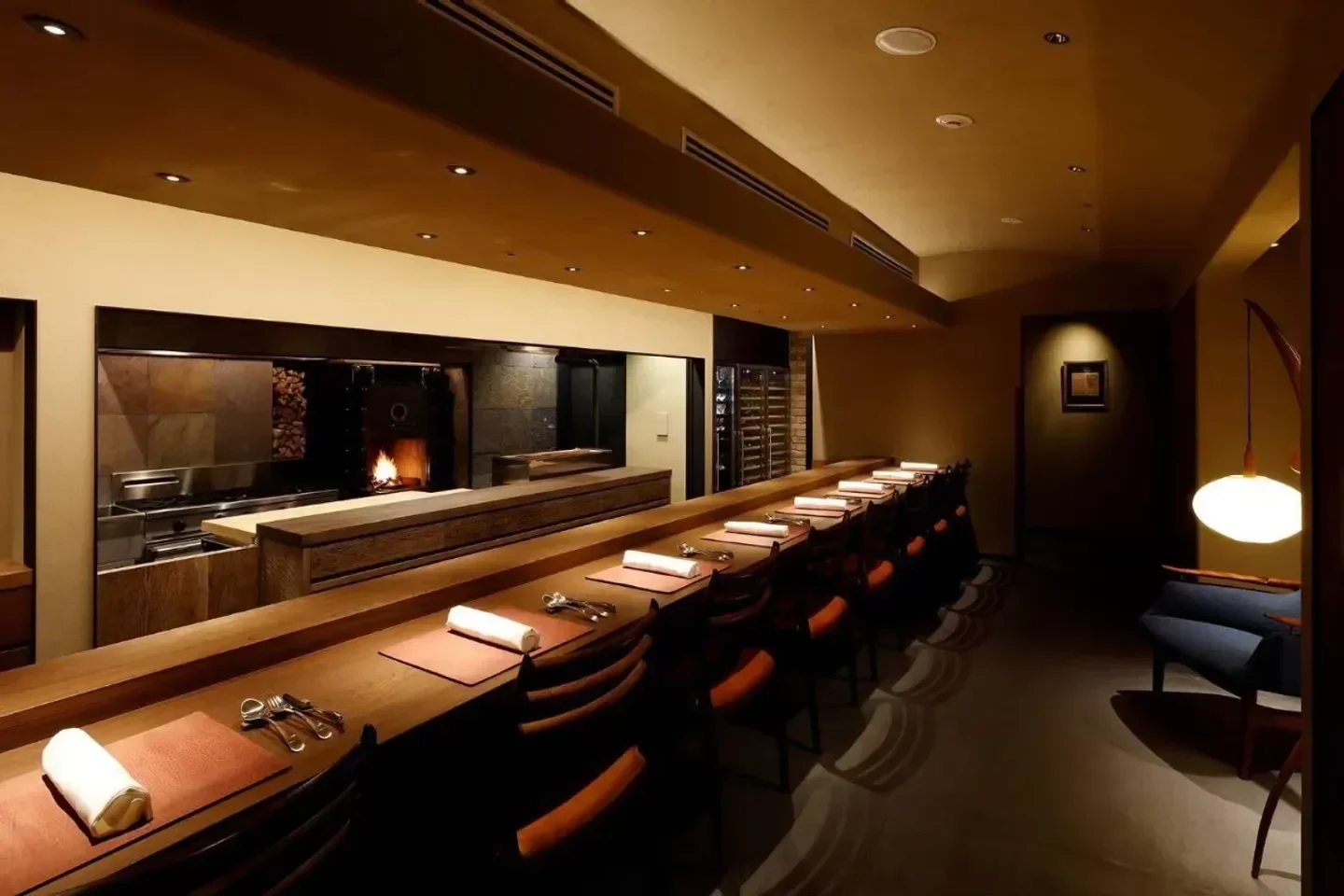 Cozy dining area at Acá 1° restaurant in Tokyo, with warm lighting and a fireplace