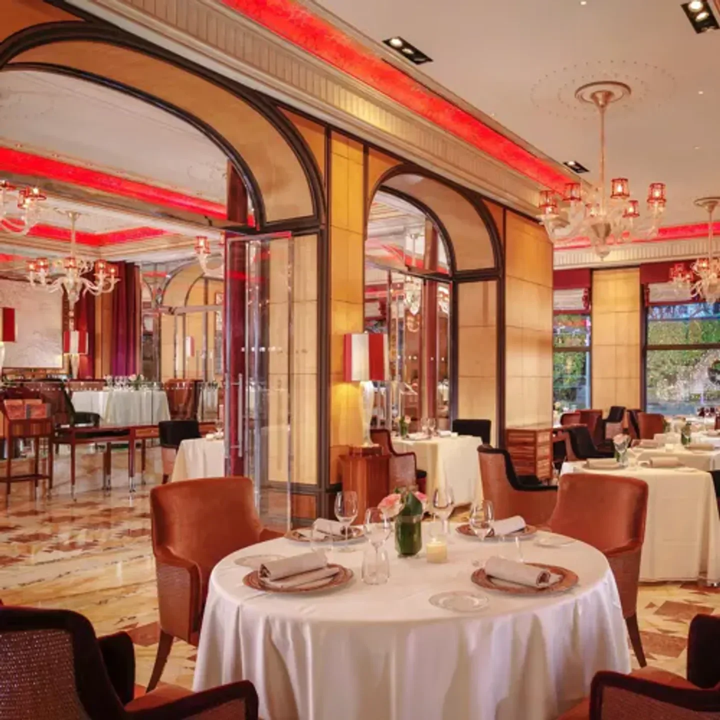 Elegant dining room interior at Acanto restaurant in Milan, with tables set for dinner.