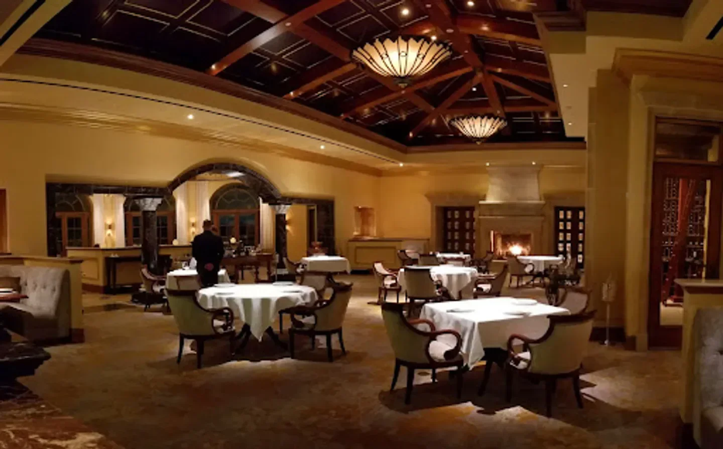 Elegant interior of Addison restaurant in San Diego, featuring a fireplace and dining tables.