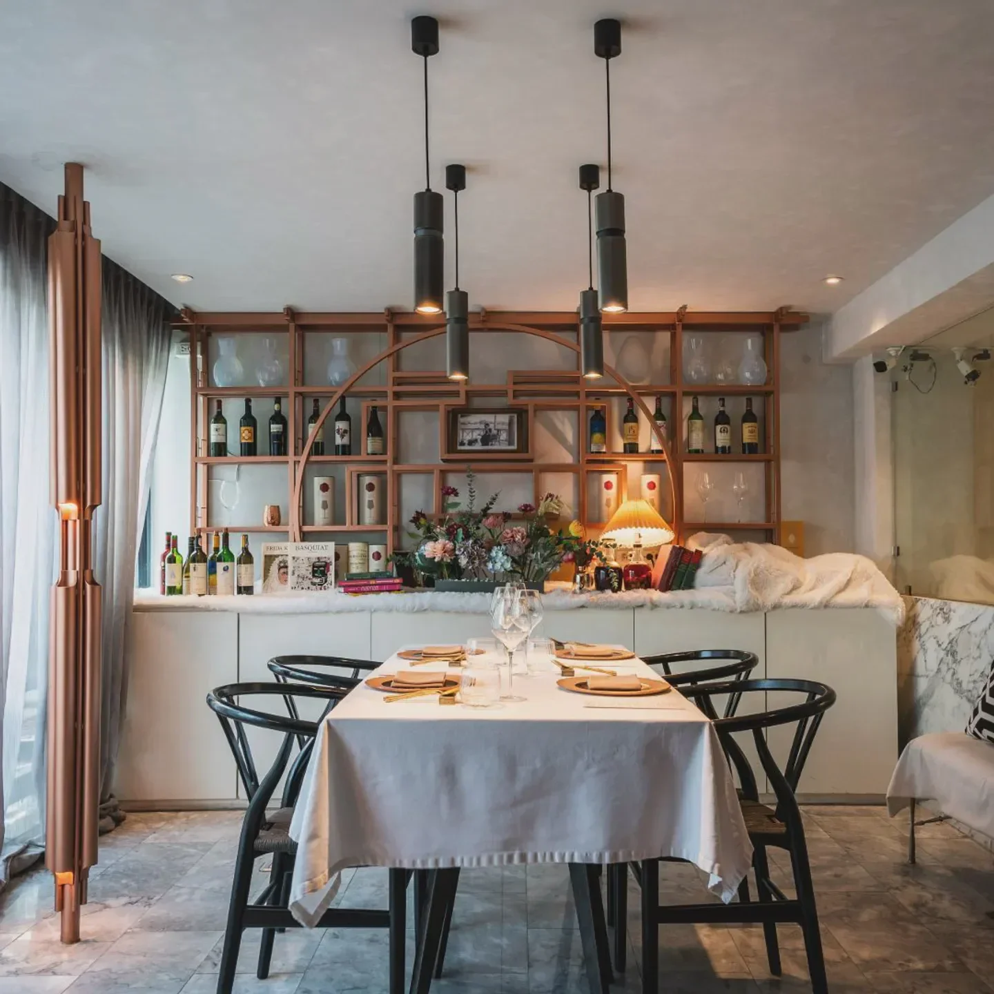 Elegant dining room interior at ADHOC Bangkok restaurant, with prepared table and stylish decor.