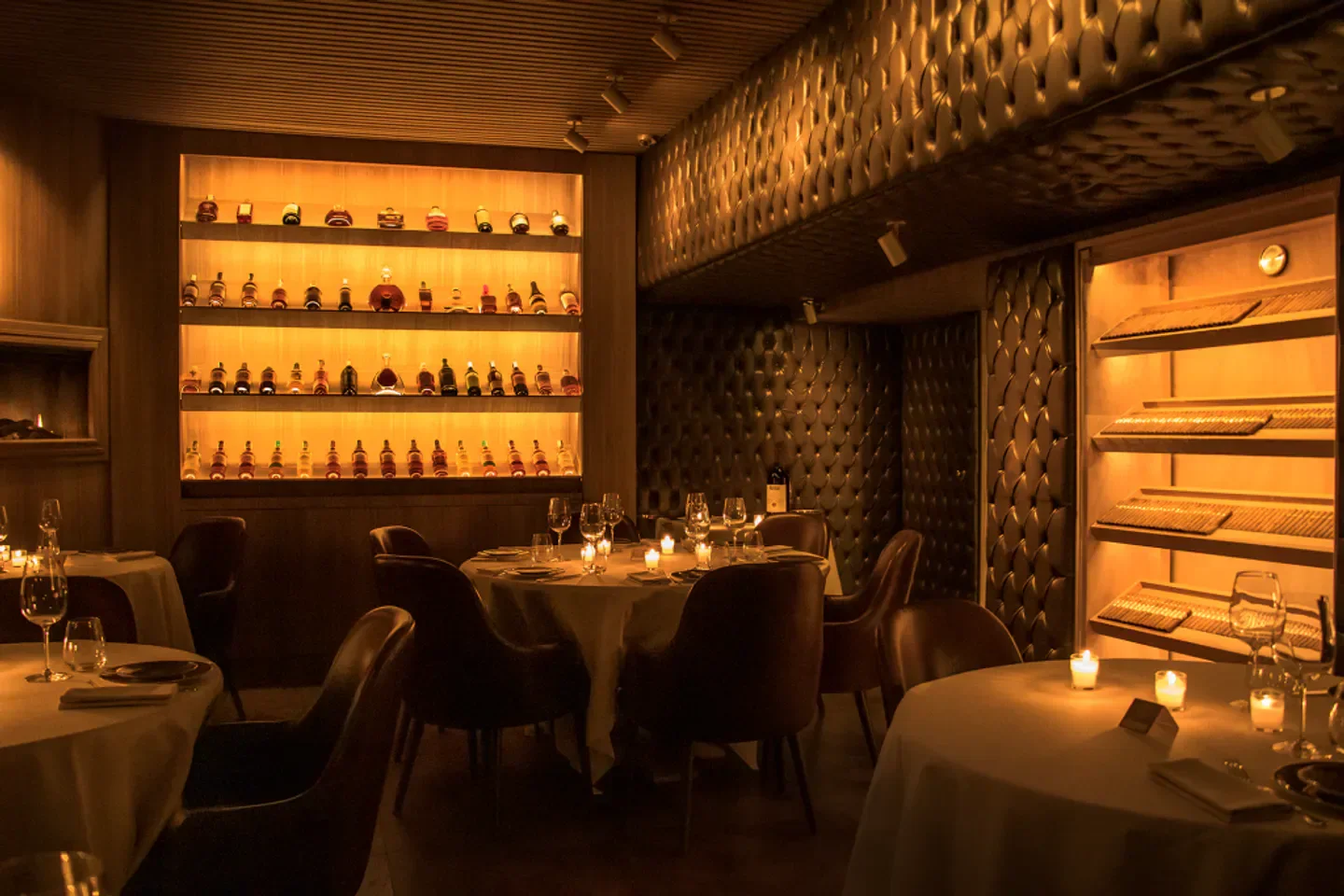 Cozy interior of AFFINATORE restaurant in Milan, with inviting candlelit tables and wine selection.