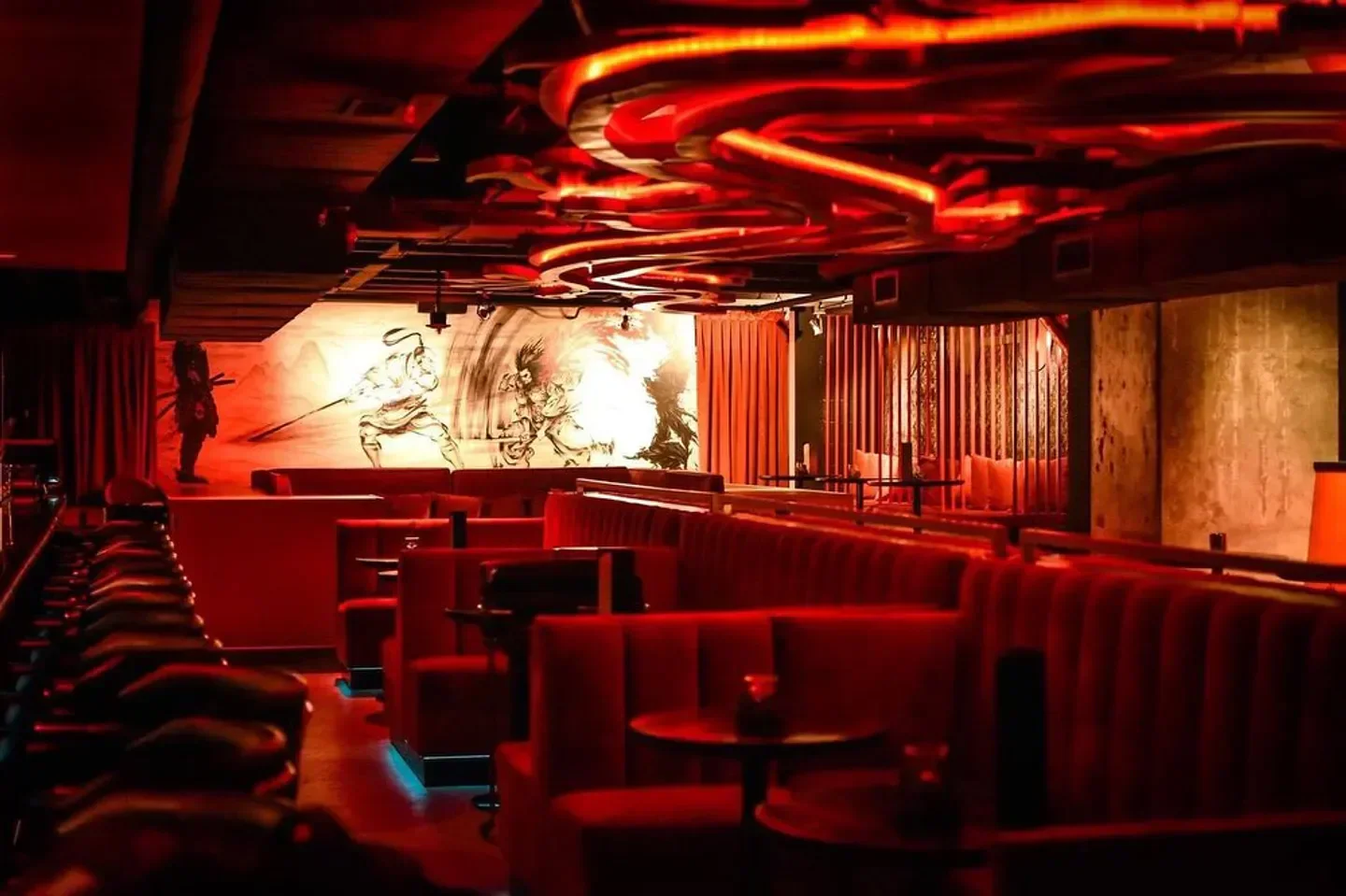 Interior of Akai nightclub in Dallas with red lighting and unique mural.