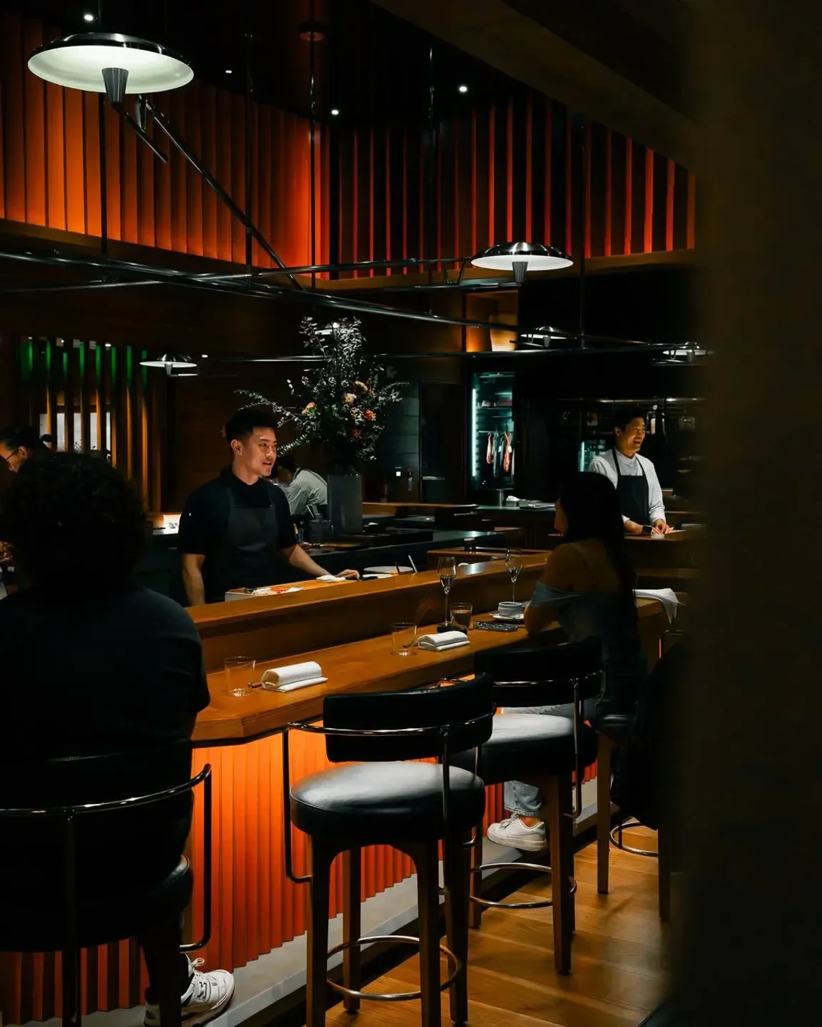 Interior view of AKIKOS restaurant in San Francisco with bar seating and staff.