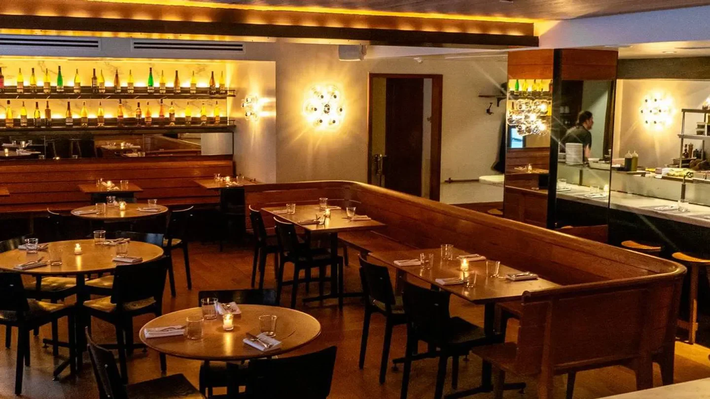 Cozy dining room at a.kitchen bar in Philadelphia, featuring wooden tables and bar.