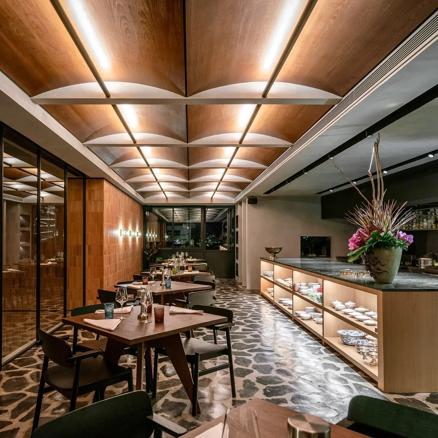 Elegant interior of Aksorn restaurant in Bangkok, featuring unique flooring and lighting.
