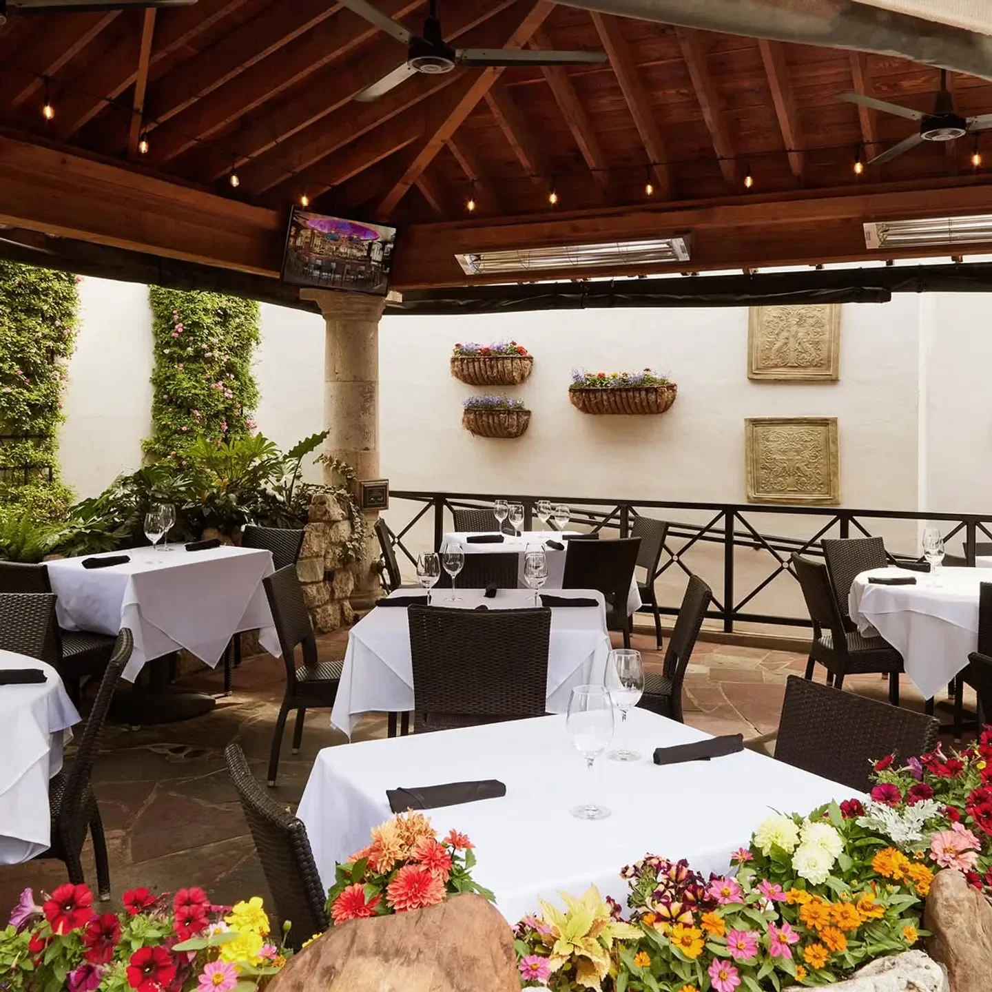 Outdoor patio at Al Biernat's in Dallas, with flower beds and tables set for dining.