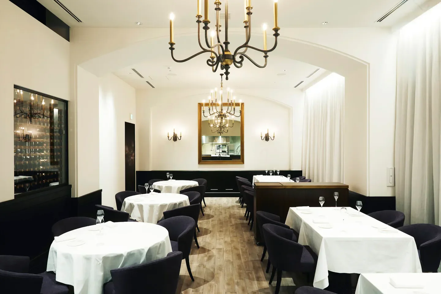 Elegant dining room at Alchimiste in Tokyo with chandeliers and tables set.