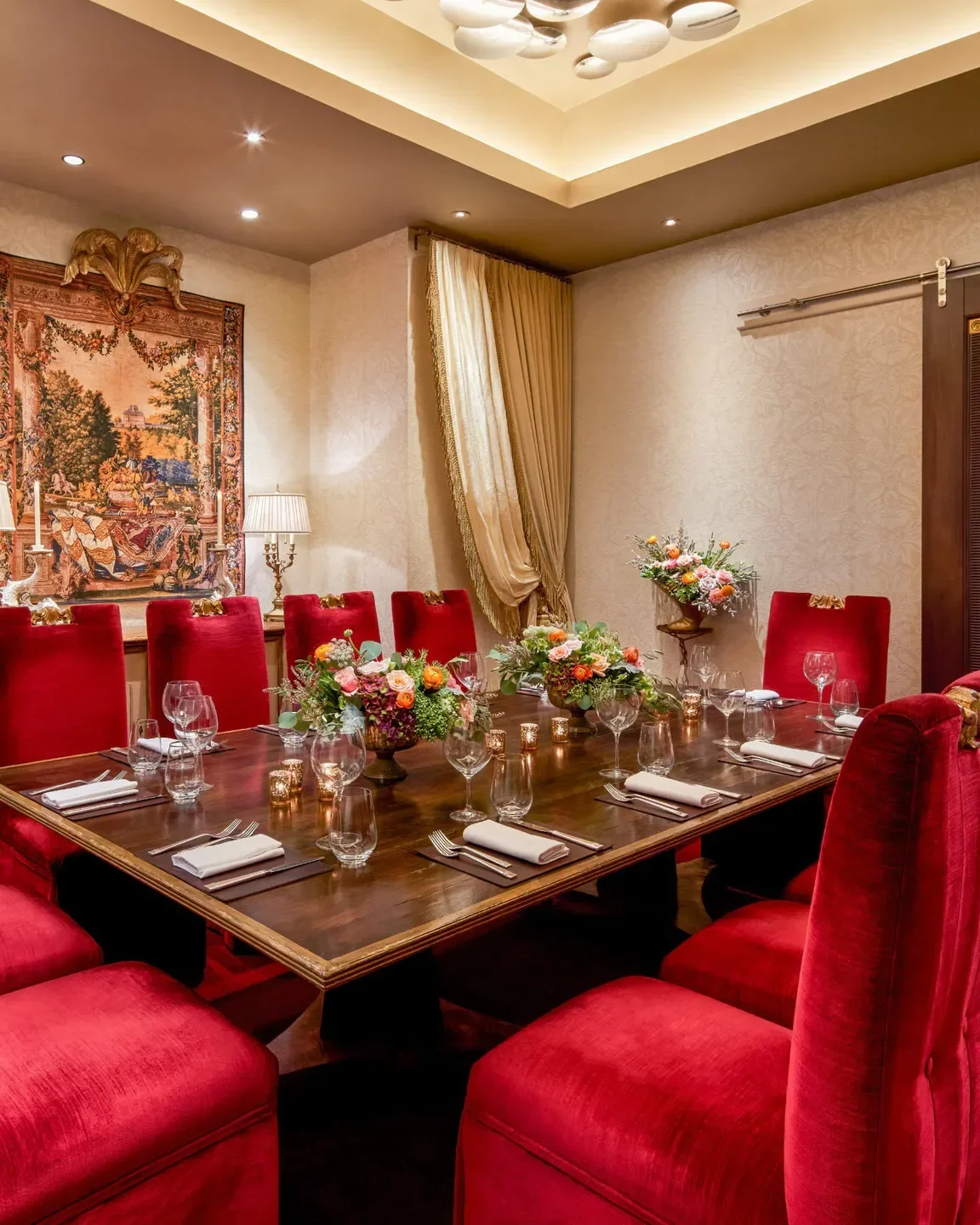 Elegant dining room at Alhambra restaurant in Washington, with red chairs and table set.