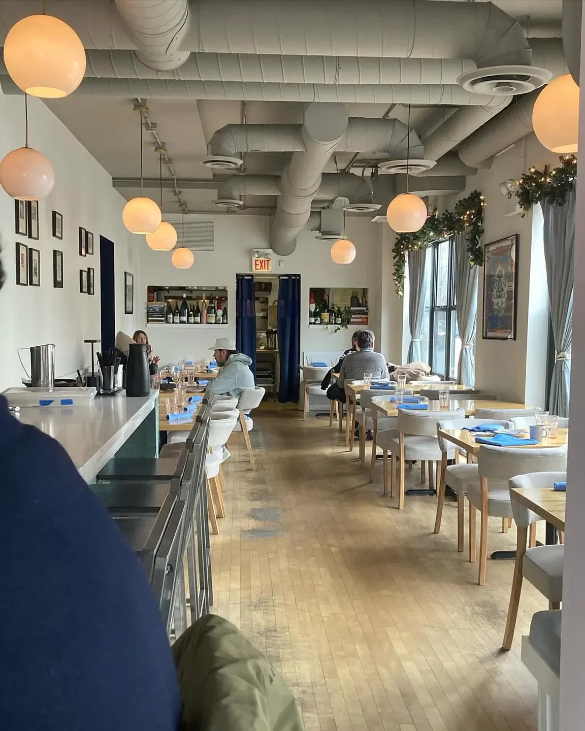 Interior of All Together Now restaurant in Chicago with hanging lights and dining tables.