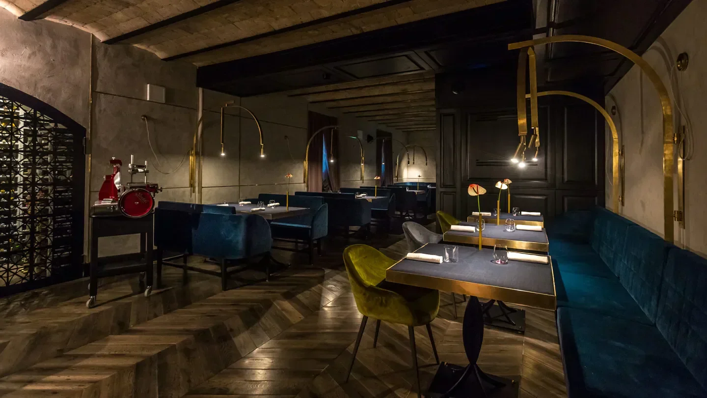 Interior of All'Oro restaurant in Rome with stylish seating and unique lighting.