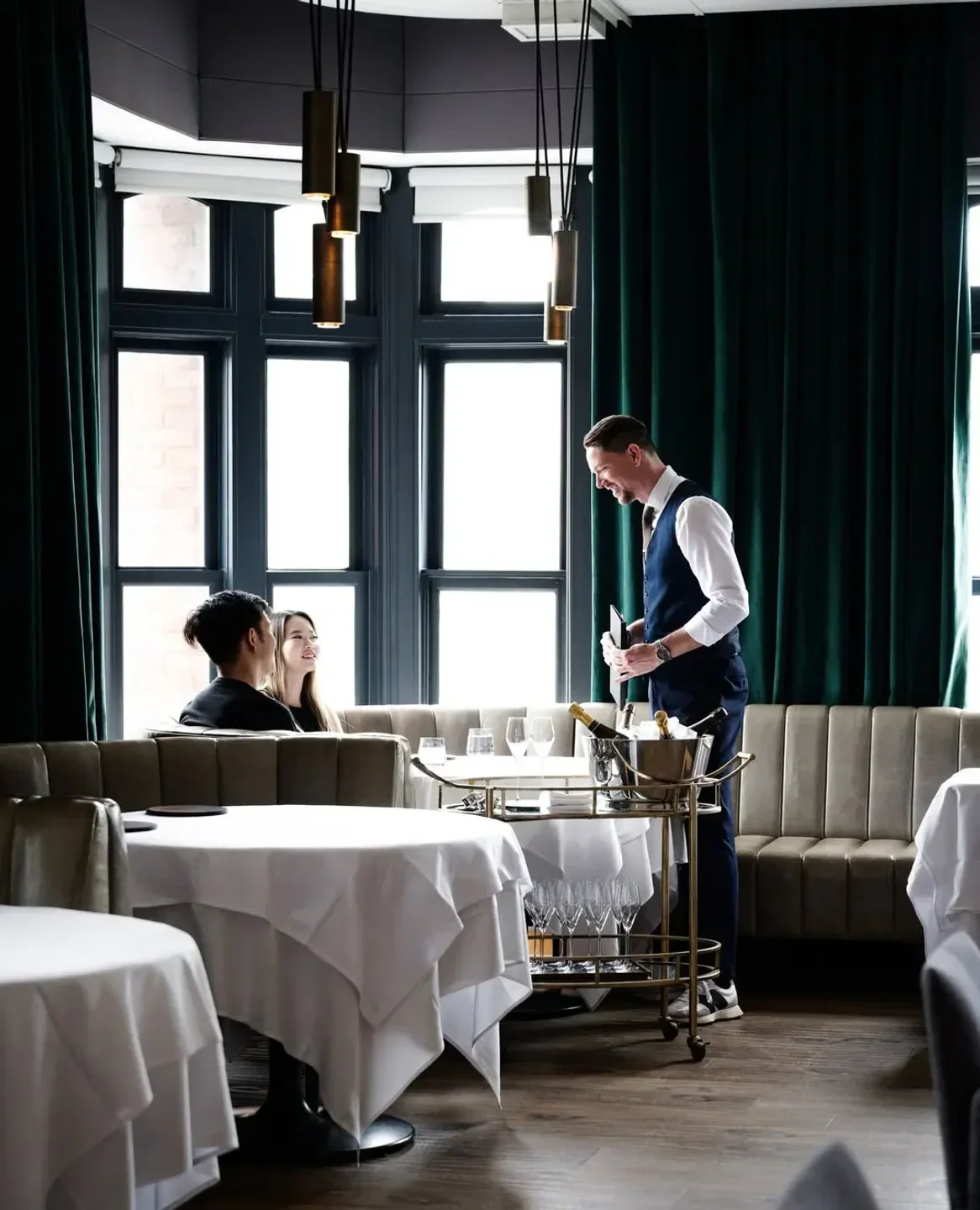 Elegant interior of Alo restaurant in Toronto, with staff attending to guests.