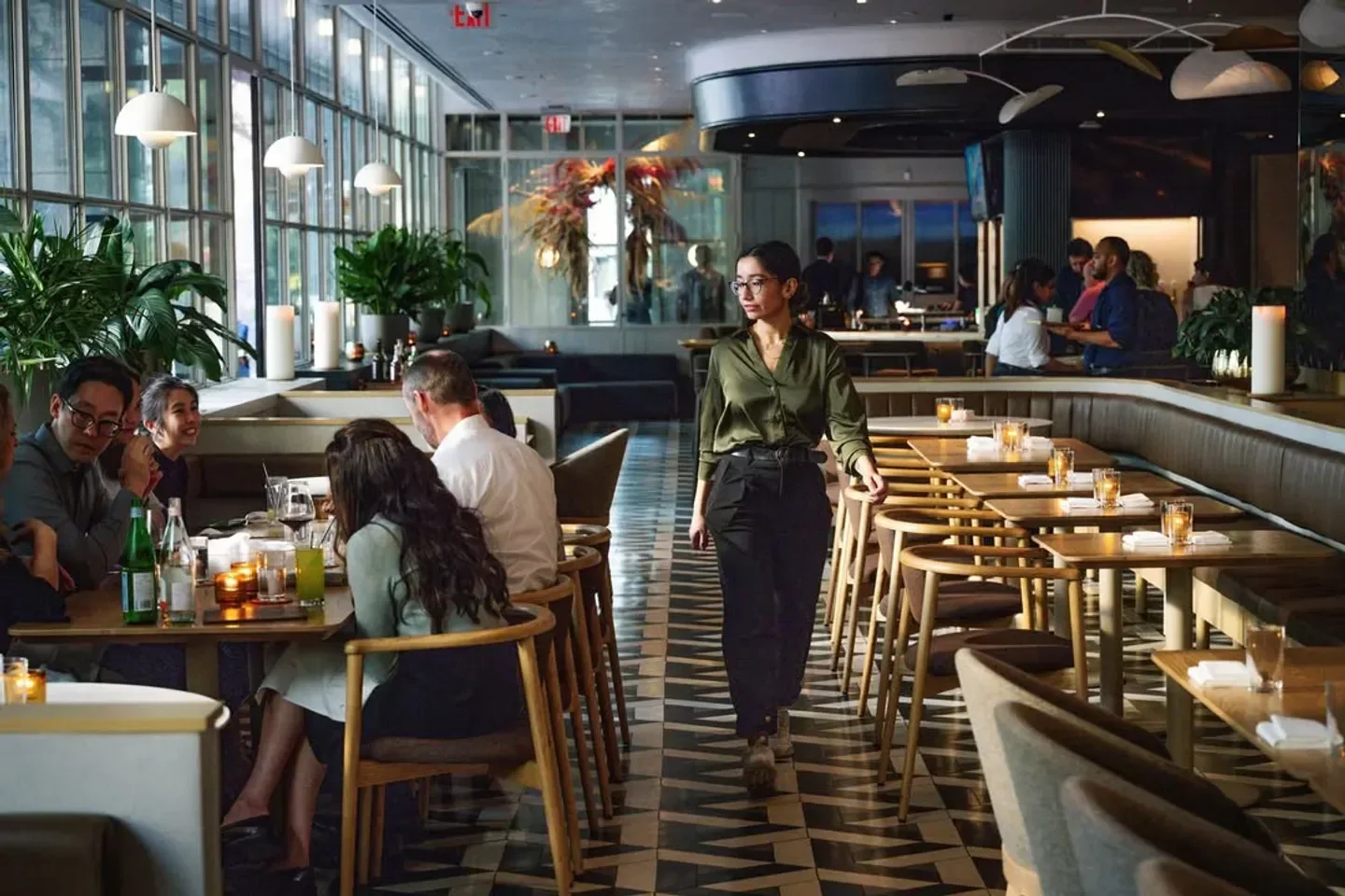 Elegant dining scene inside Alobar Yorkville restaurant in Toronto, with staff and guests.