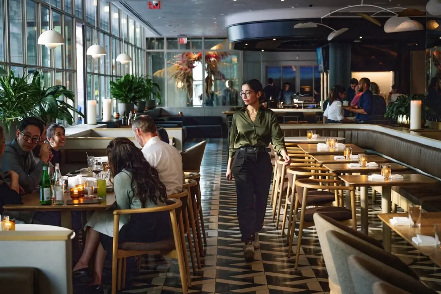 Elegant dining scene inside Alobar Yorkville restaurant in Toronto, with staff and guests.