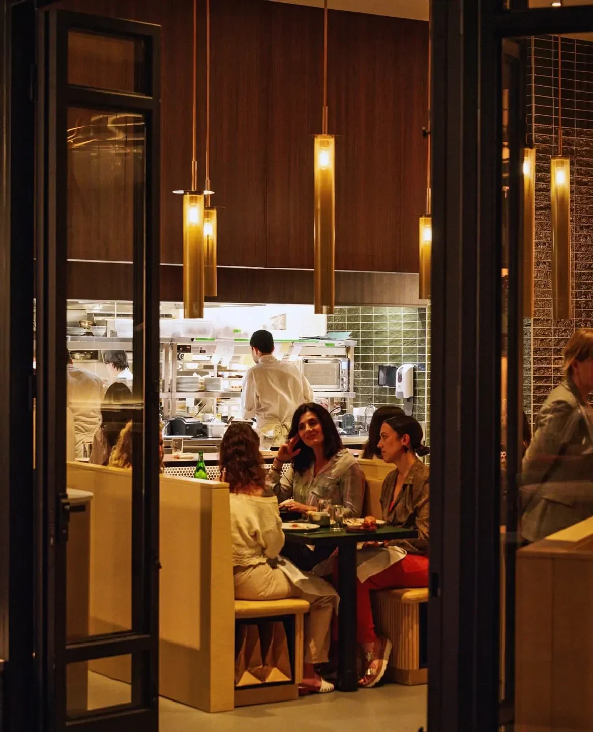 Cozy dining scene at Aloette restaurant in Toronto, with diners and open kitchen.