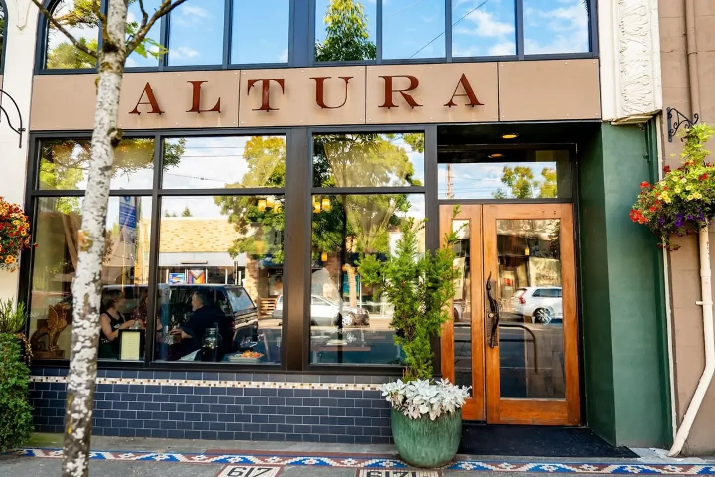 Exterior view of Altura restaurant in Seattle, with inviting glass windows and entrance.