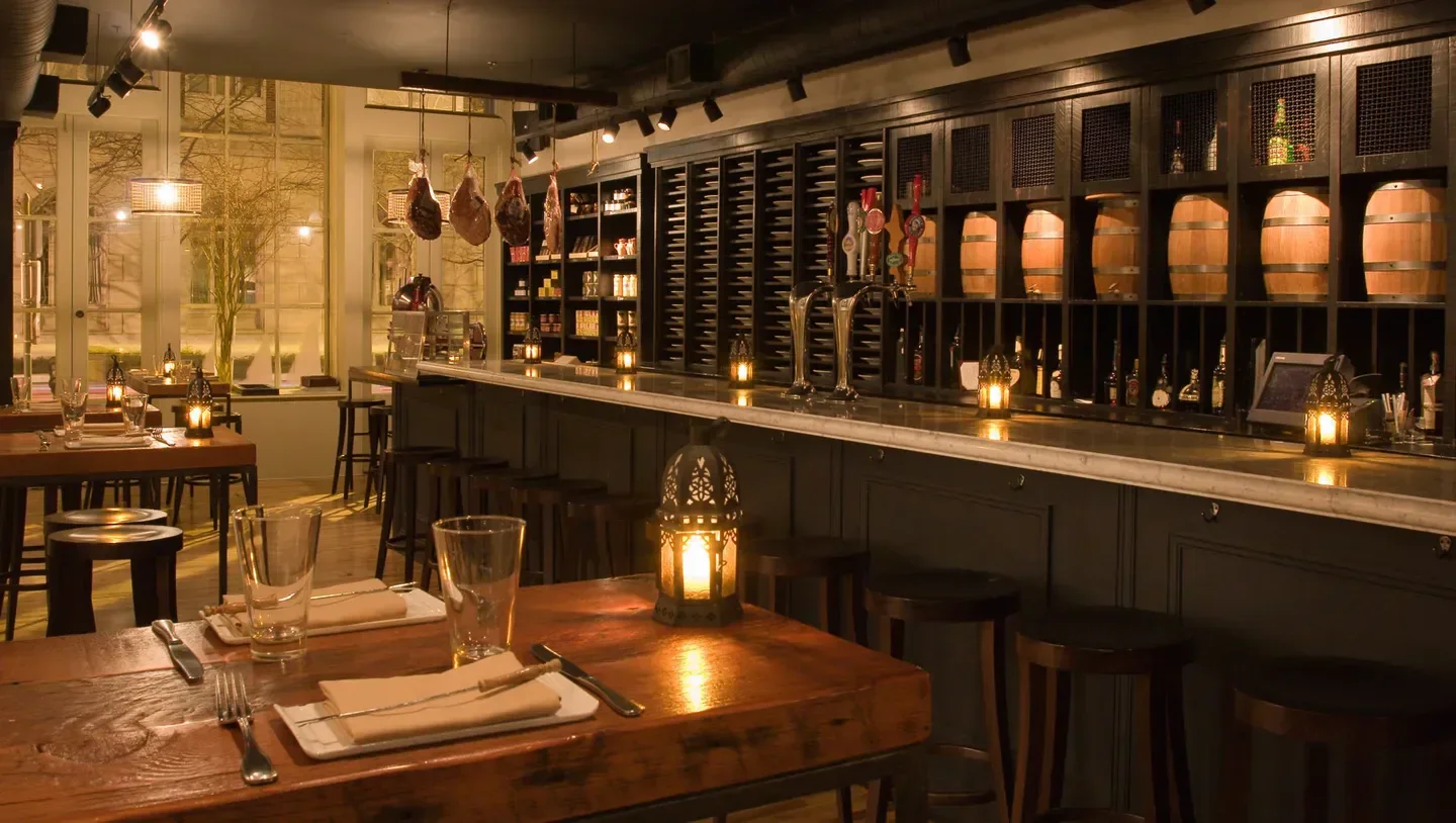 Cozy interior of Amada restaurant in Philadelphia with rustic tables and bar.