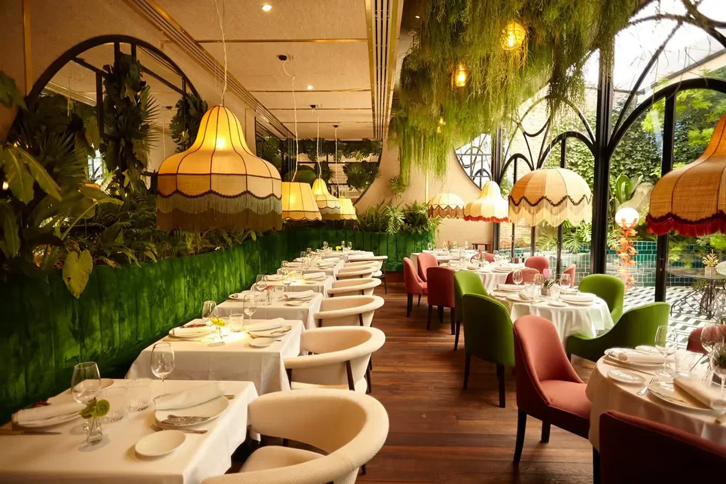 Elegant dining at Amazonico Madrid: Lush greenery, unique lighting, and stylish decor.