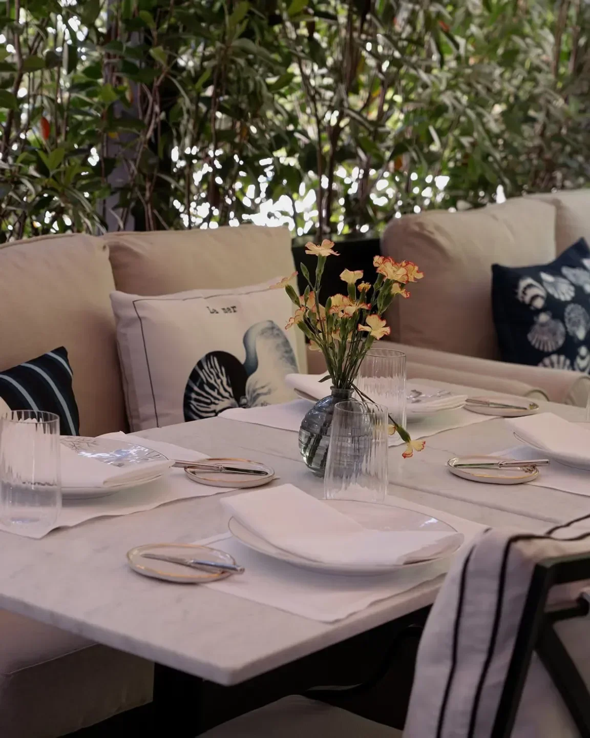 Elegant outdoor dining at AMÓS Restaurante in Madrid, featuring flowers and a marble table.