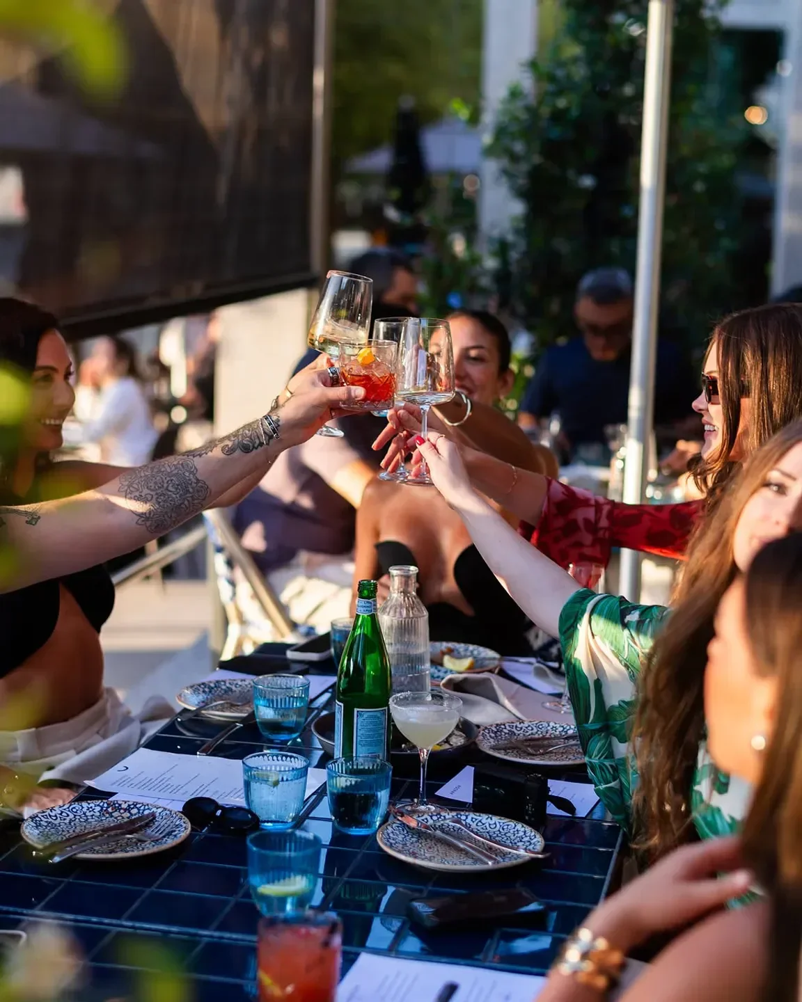 Cheers at Anason Sydney restaurant: Friends toasting with drinks at a stylish table.