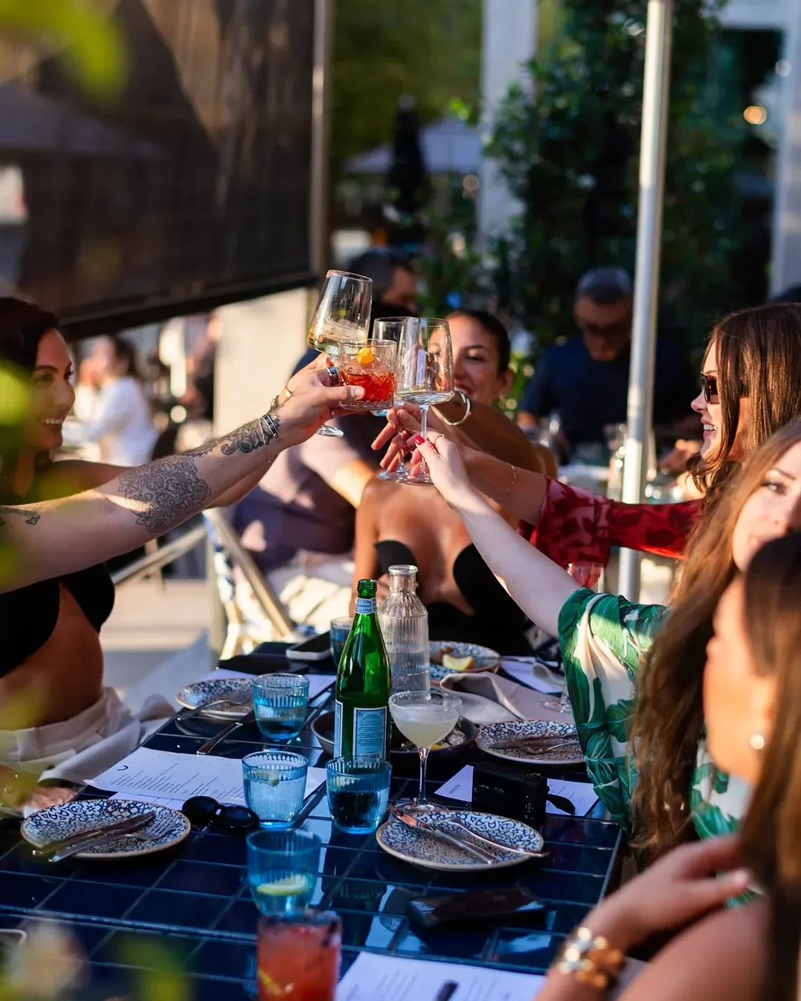 Cheers at Anason Sydney restaurant: Friends toasting with drinks at a stylish table.