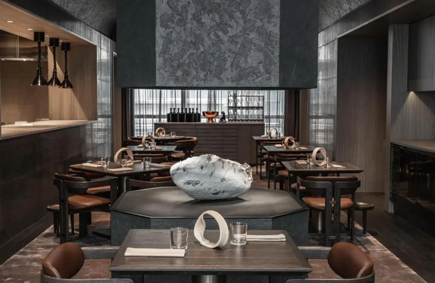 Interior of Andō restaurant in Hong Kong, featuring a unique centerpiece and dining tables