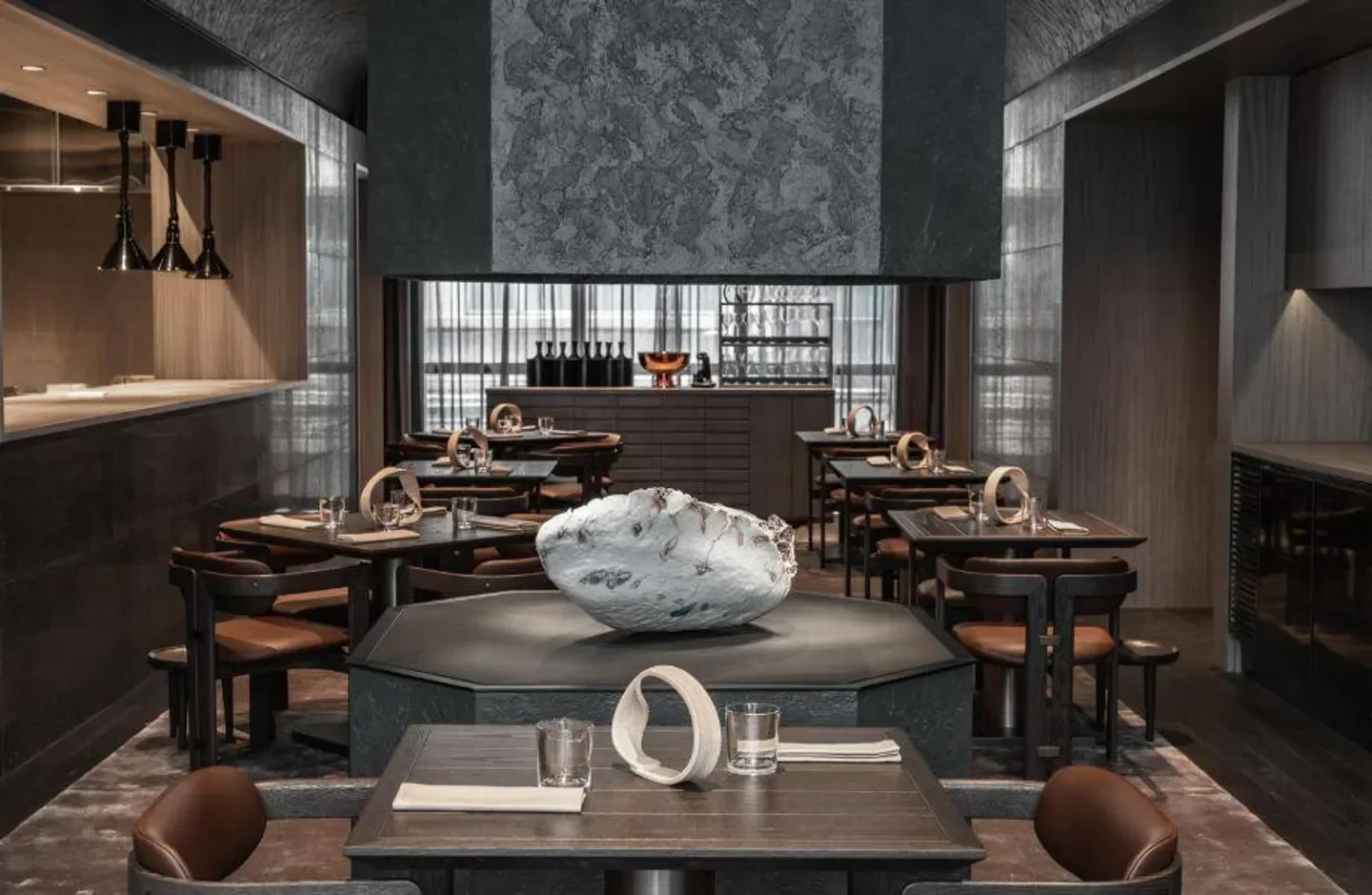 Interior of Andō restaurant in Hong Kong, featuring a unique centerpiece and dining tables