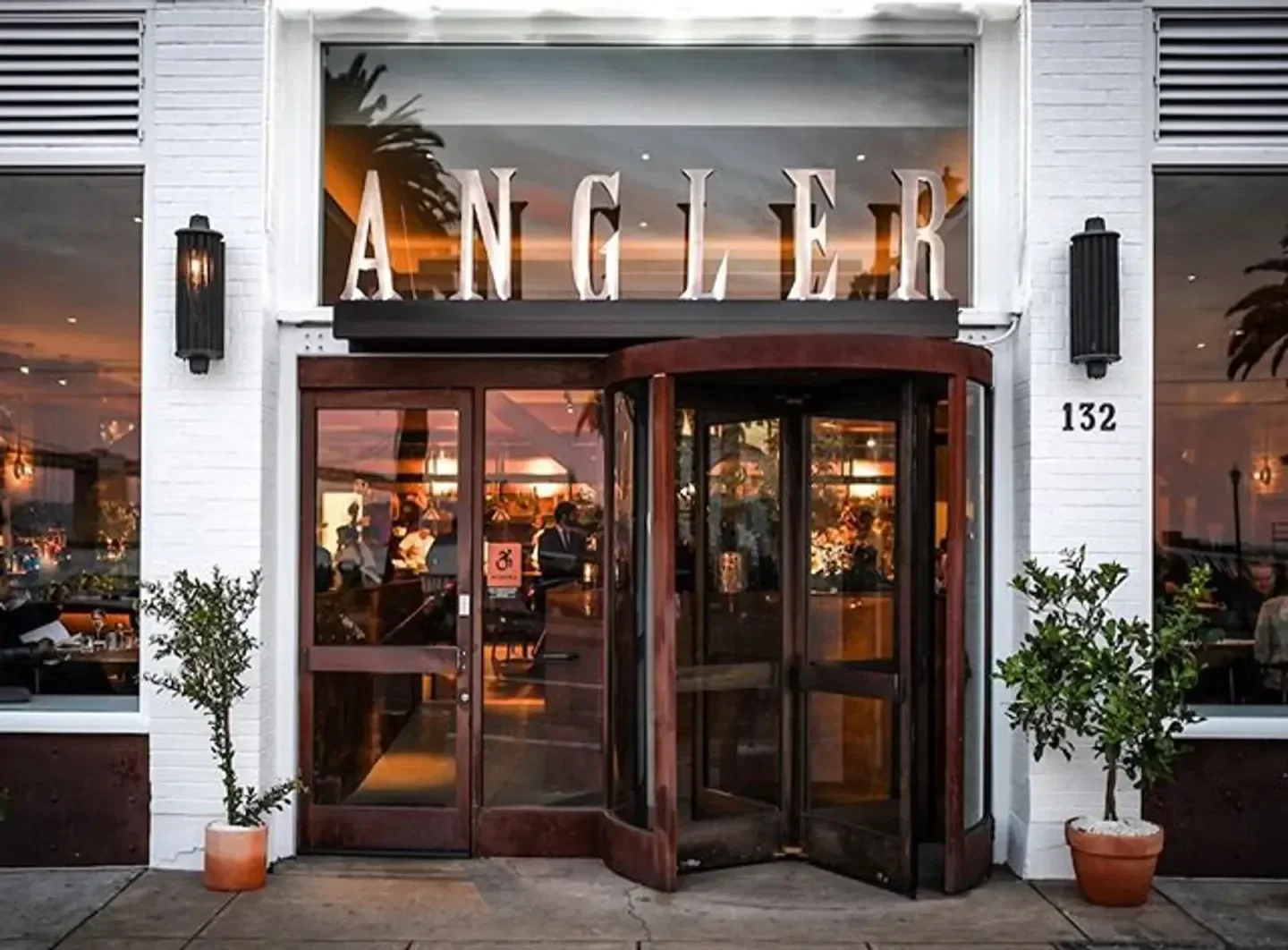 Entrance to Angler SF restaurant in San Francisco, featuring revolving doors and stylish design.