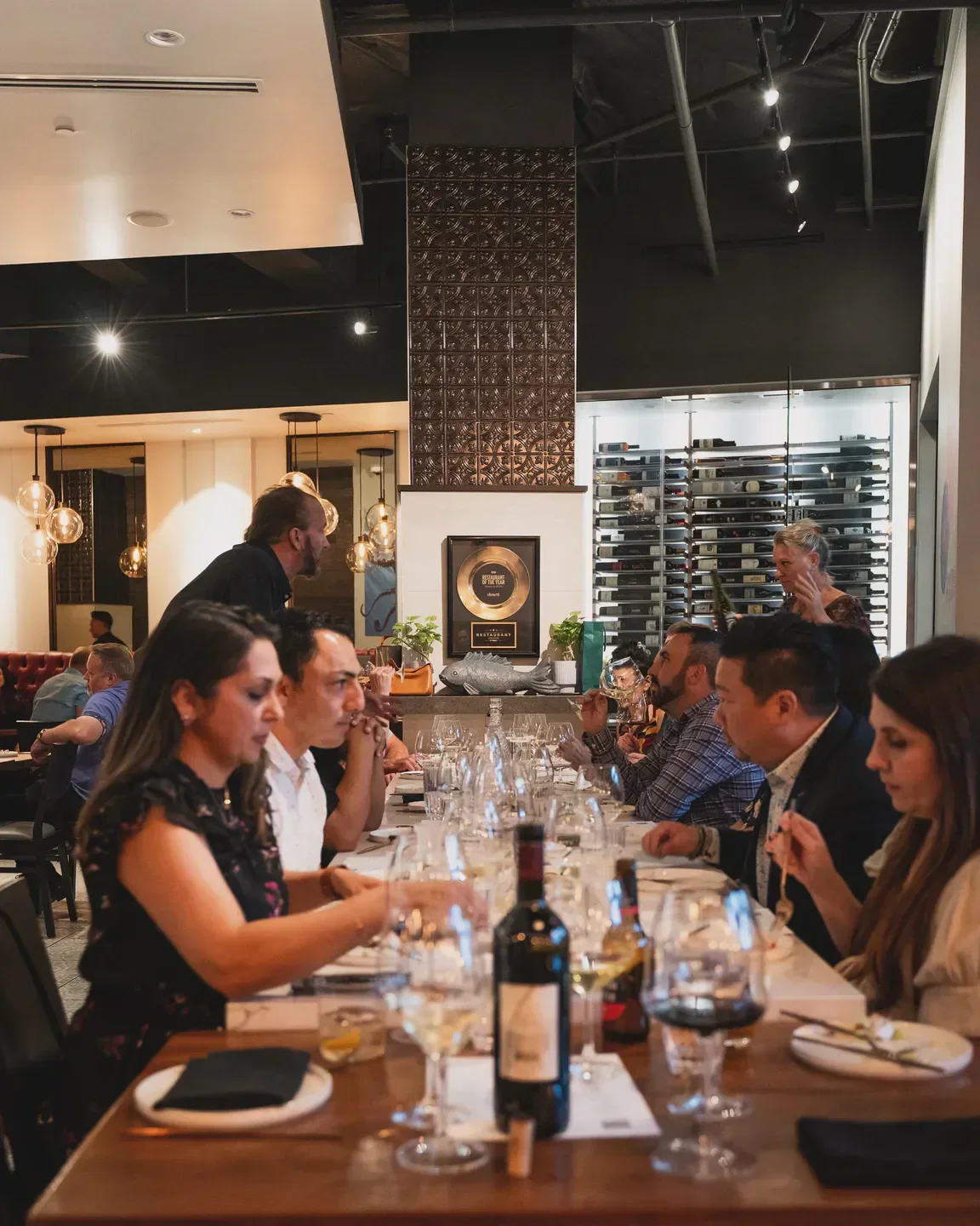 Dining at Anima by EDO in Las Vegas: guests enjoying food and wine.