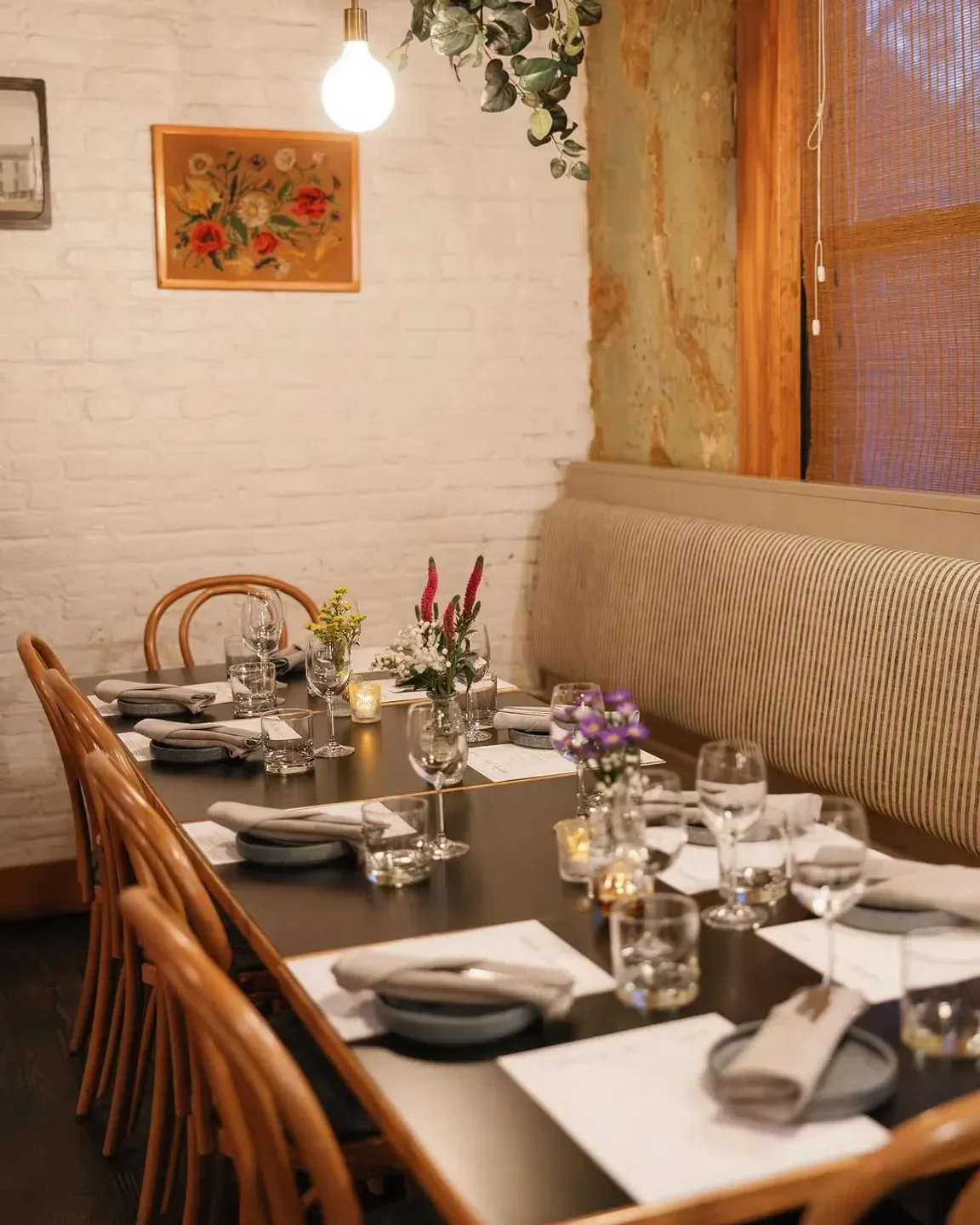 Cozy dining area at Anju restaurant in Washington, featuring floral arrangements and elegant table settings.