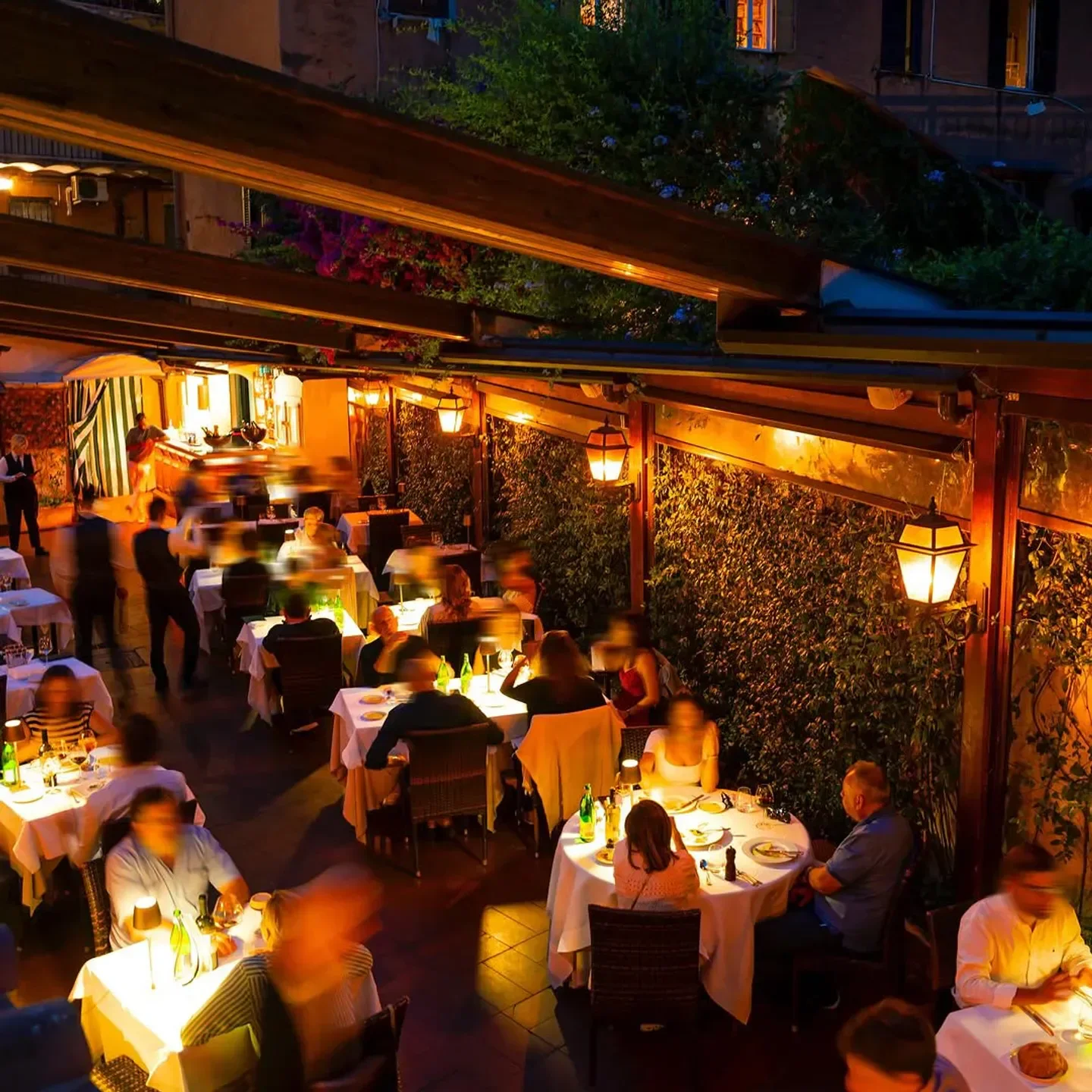 Outdoor dining at Antica Pesa restaurant in Rome with soft lighting and cozy atmosphere.