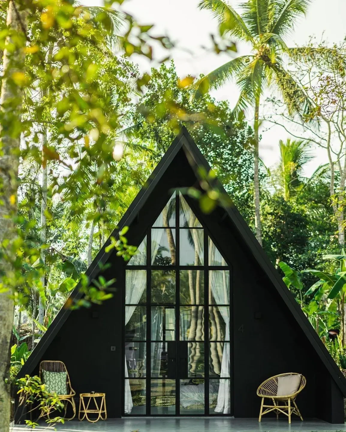 Apdikt restaurant in Luxembourg, a modern, black A-frame building surrounded by lush trees