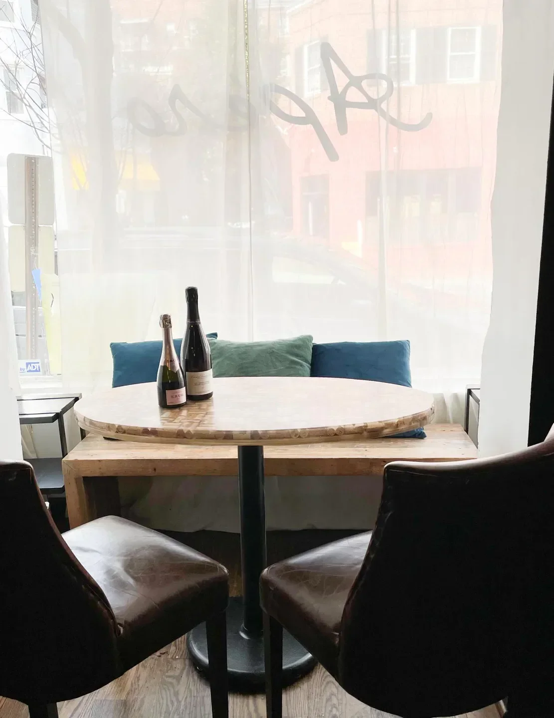Cozy seating area with wine bottles at Apéro restaurant in Washington, DC.