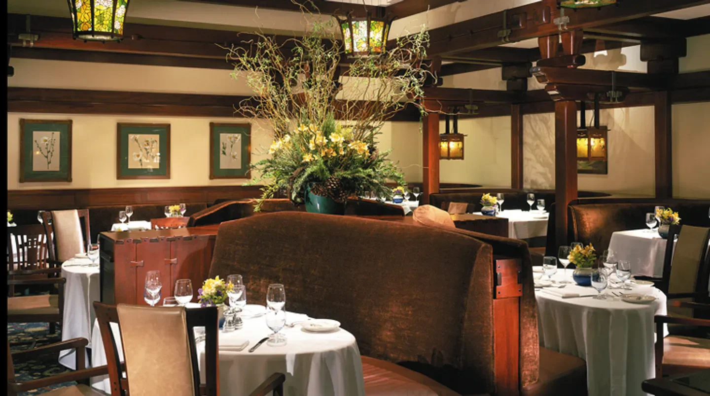 Elegant dining room at A.R. Valentien in San Diego, featuring cozy booths and floral arrangements.