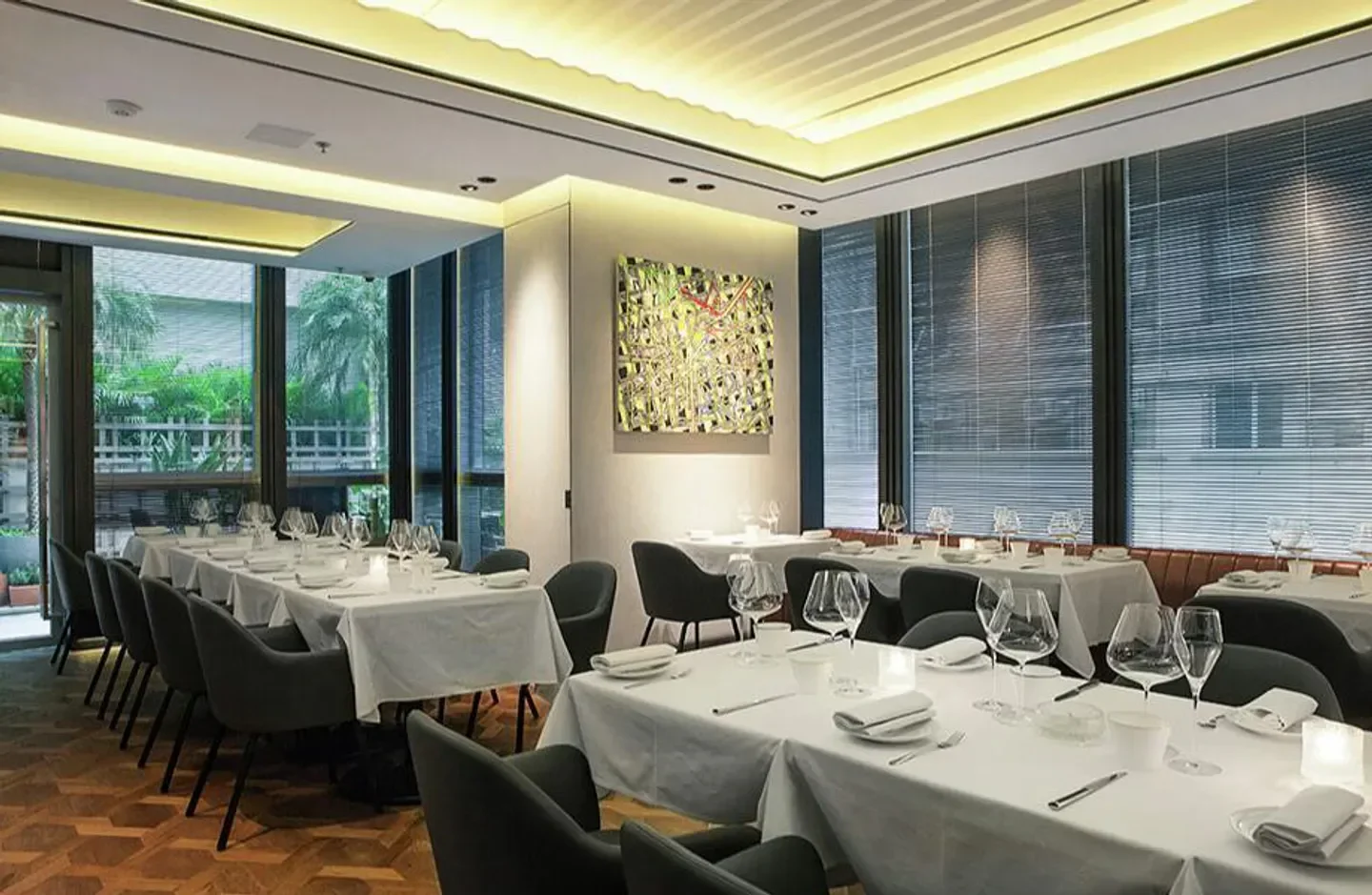 Elegant dining room interior at Arcane restaurant in Hong Kong, with tables set.