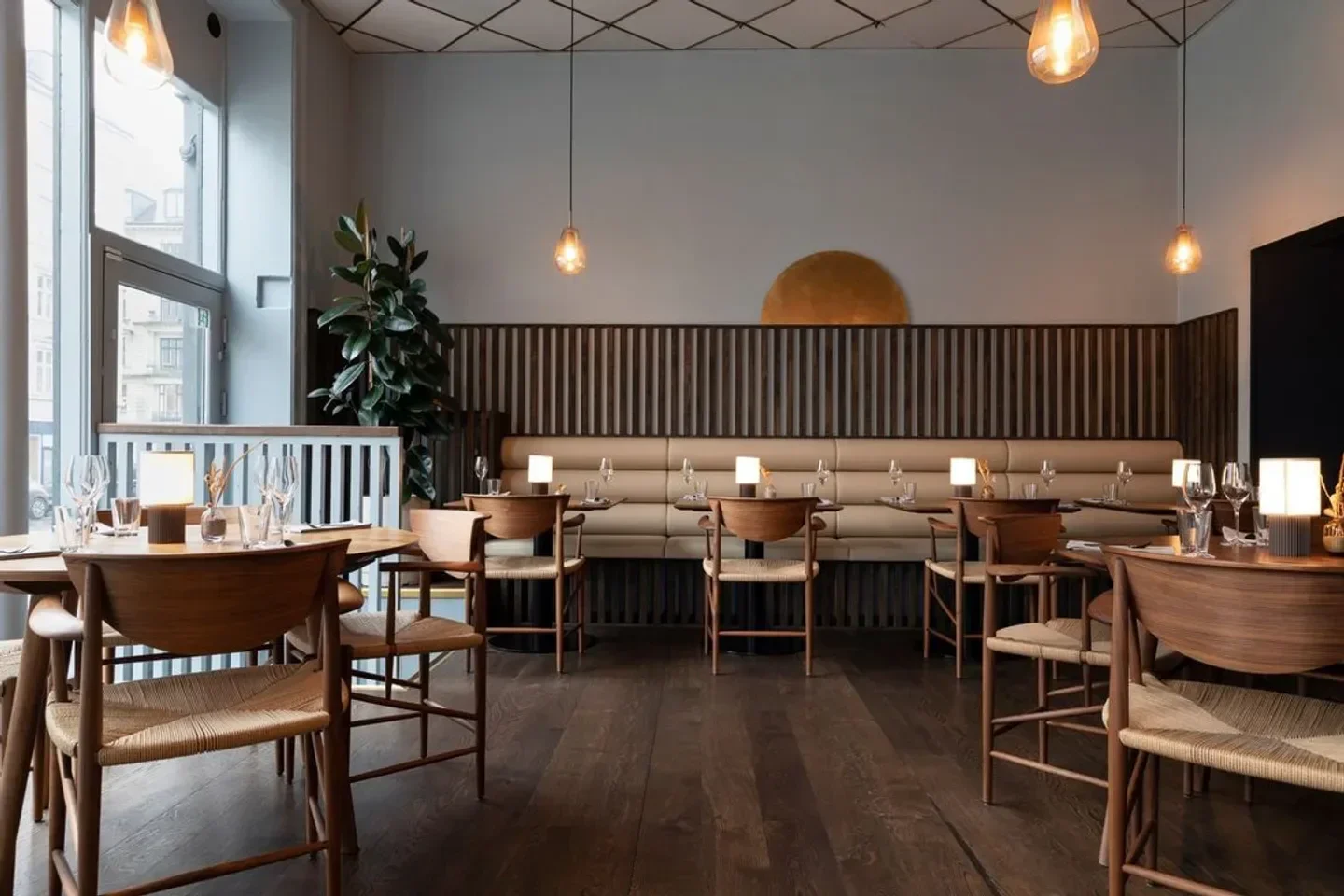 Interior of ARK restaurant in Copenhagen, featuring wooden chairs and tables.