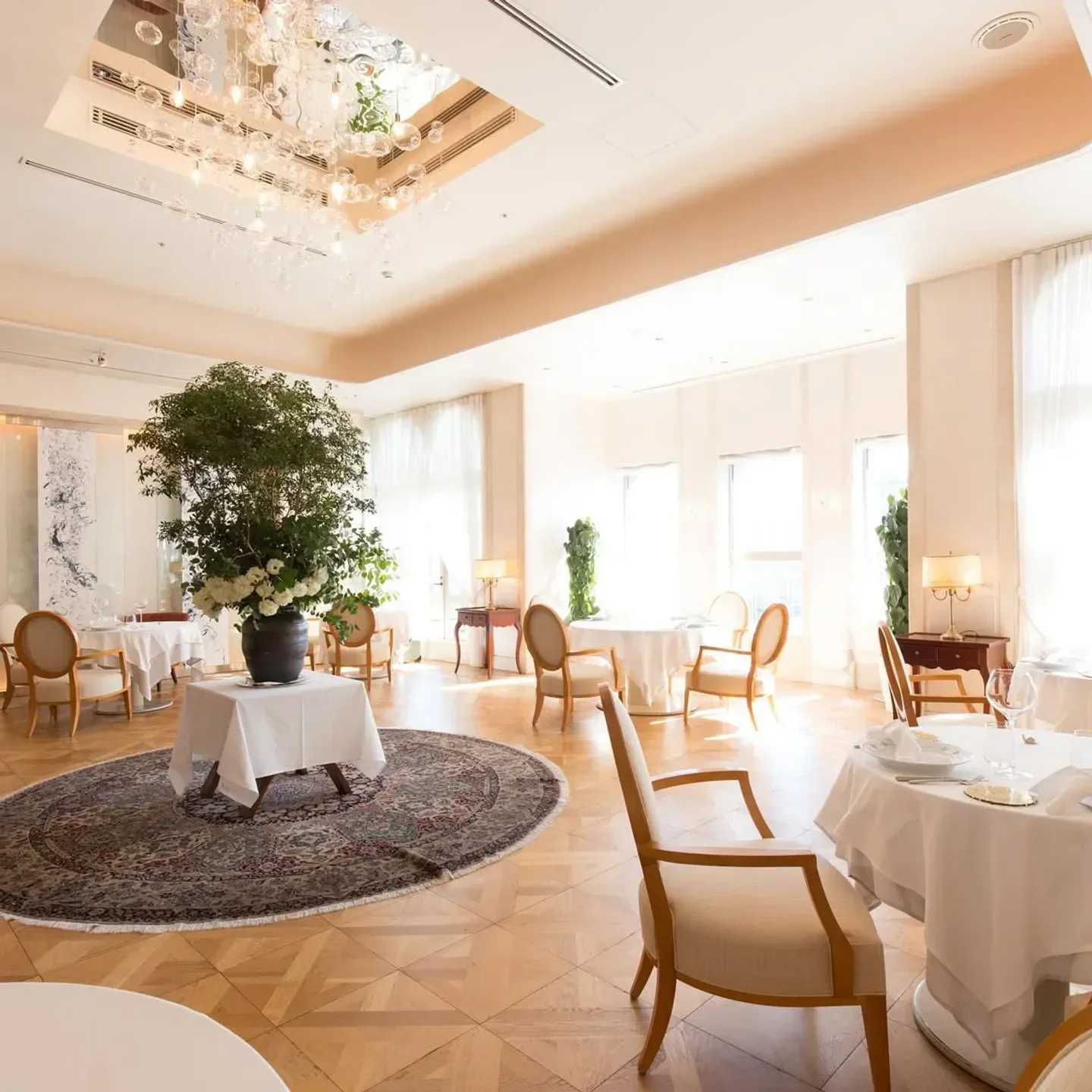 Elegant dining room interior at Aroma Fresca in Tokyo, featuring tables and a chandelier.