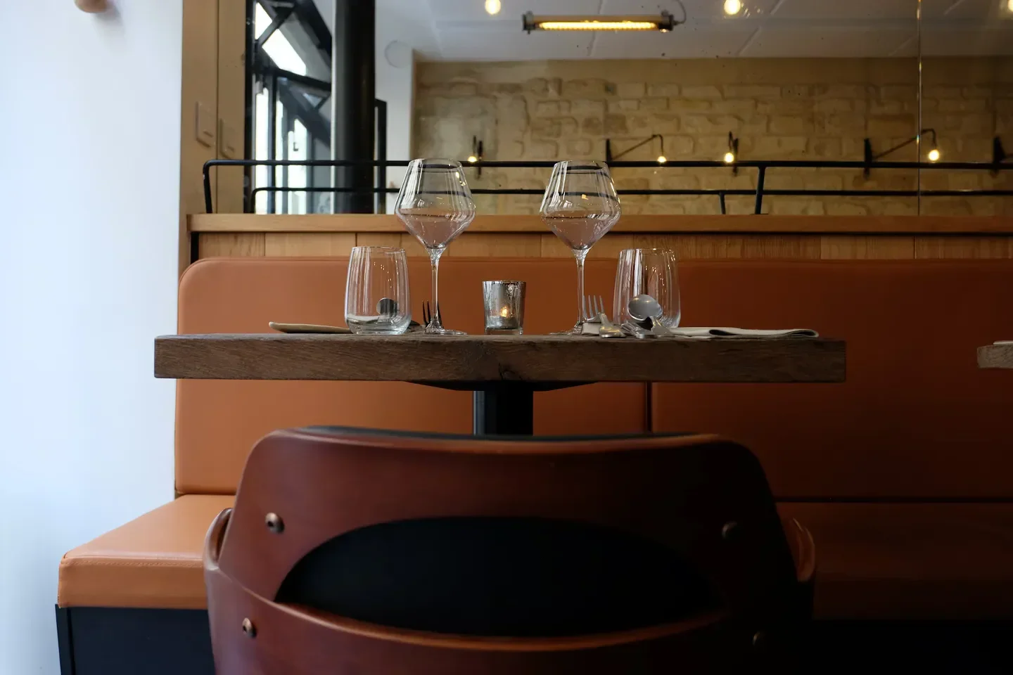 Table setting at Aspic restaurant in Paris, featuring glasses and a candle.