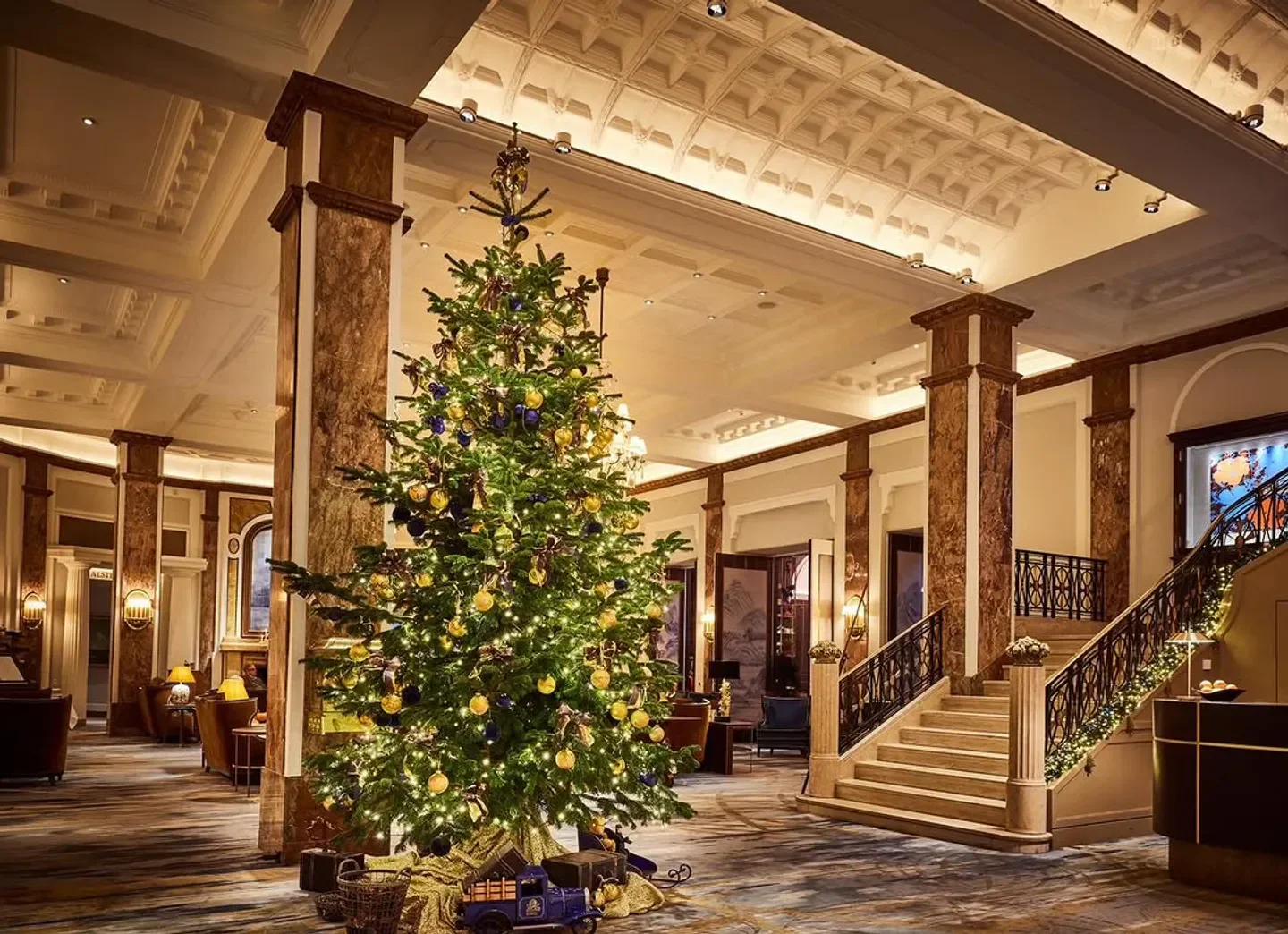 Festive Christmas tree at Atlantic Restaurant in Hamburg, with elegant interior and staircase