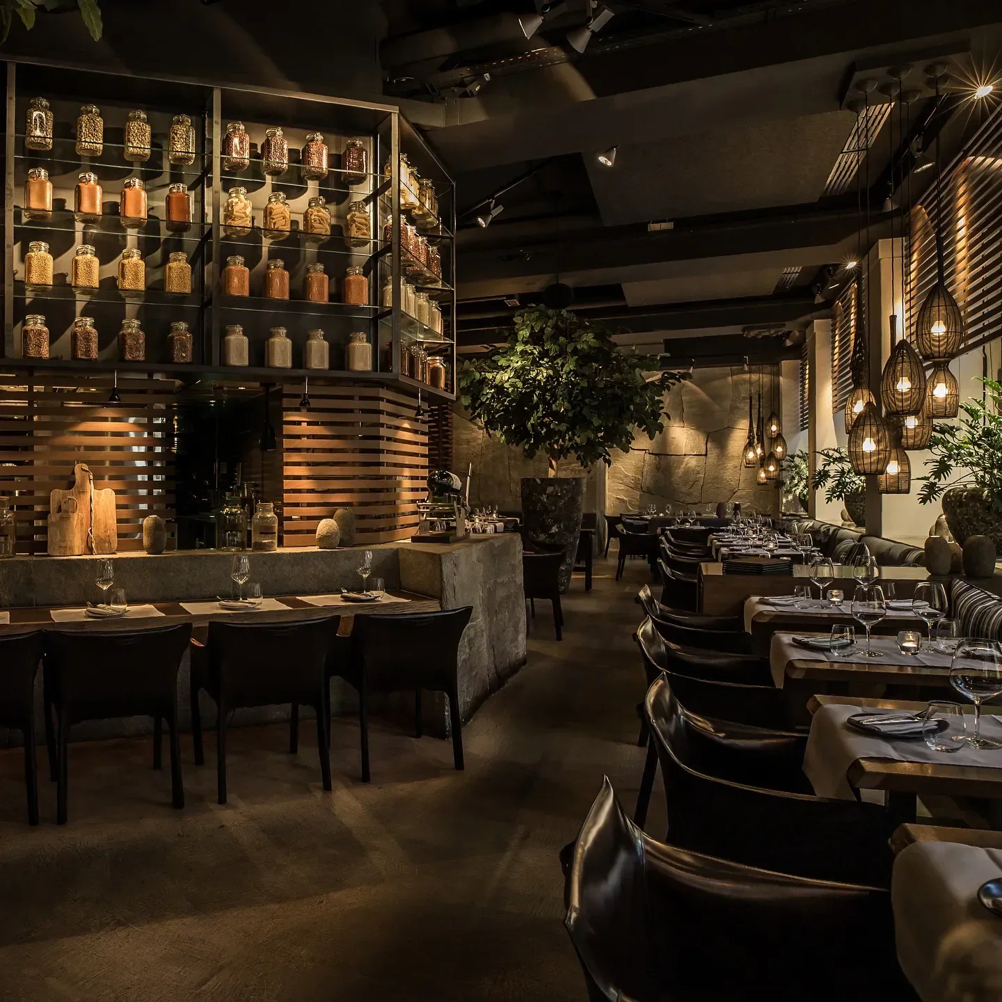 Interior of Aura restaurant in Zurich, showcasing elegant dining, jars of spices and ambient lighting.
