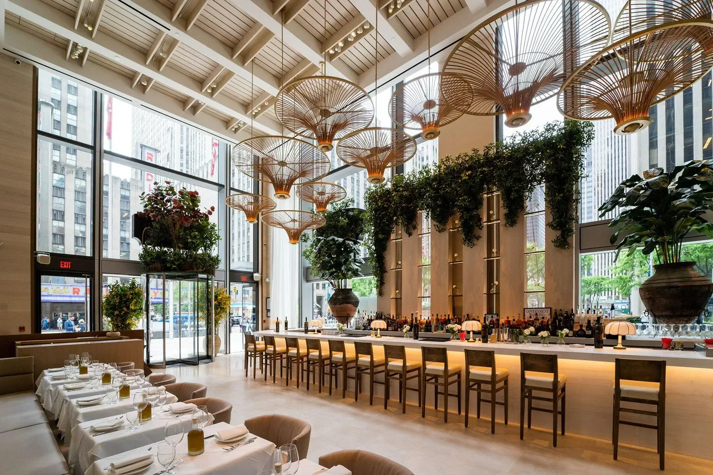 Stylish interior of Avra Las Vegas restaurant with hanging lamps and bar seating.