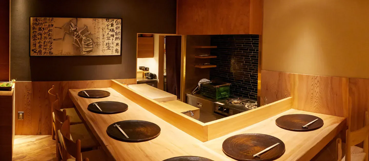 Elegant dining space at Azabu Wakei in Tokyo, featuring wooden tables and a chef's area.